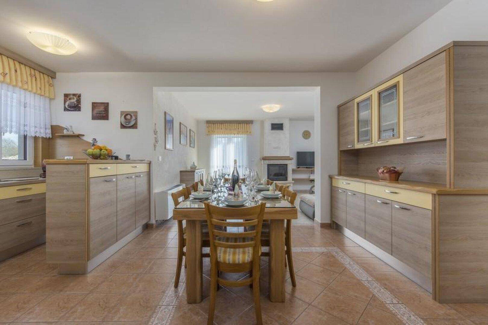 Geräumiger Essbereich mit großem Holztisch, der offen in das Wohnzimmer übergeht.