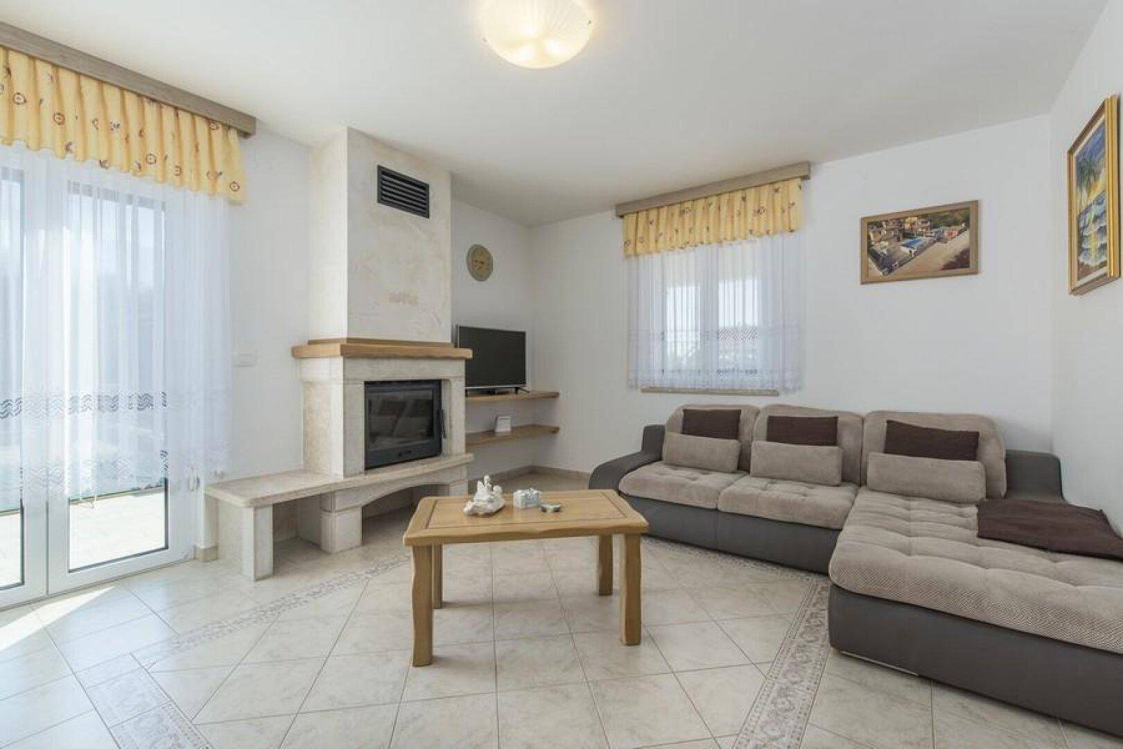 Gemütliches Wohnzimmer mit Ecksofa, Couchtisch und Kamin, ideal zum Entspannen.