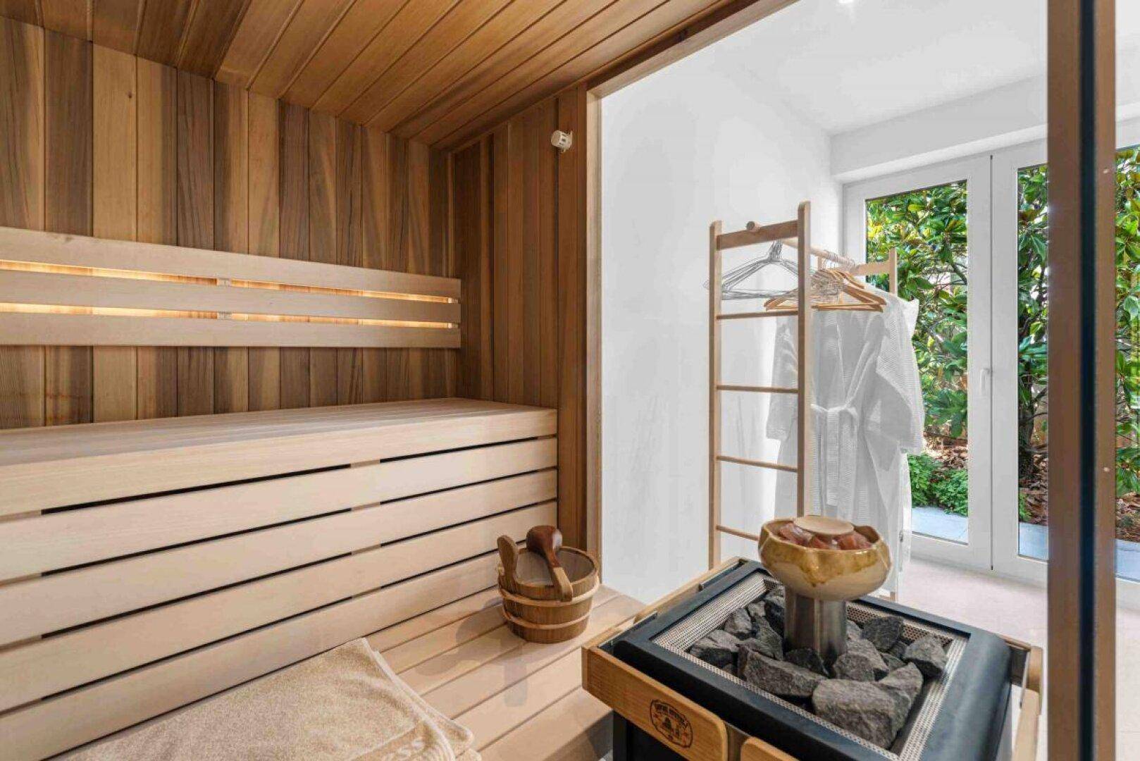 Moderne Sauna mit Holzbänken und direktem Zugang zum Gartenbereich.