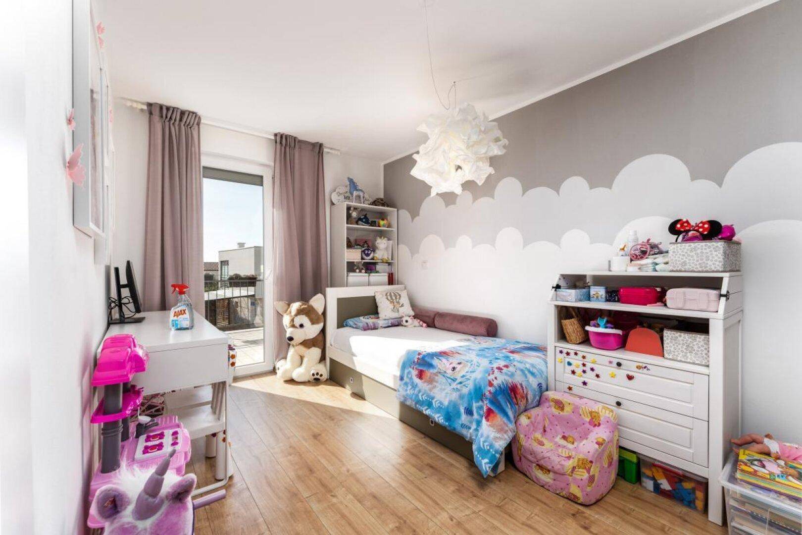 Kinderzimmer mit verspielter Wolkenwand, Schreibtisch und Zugang zum Balkon.
