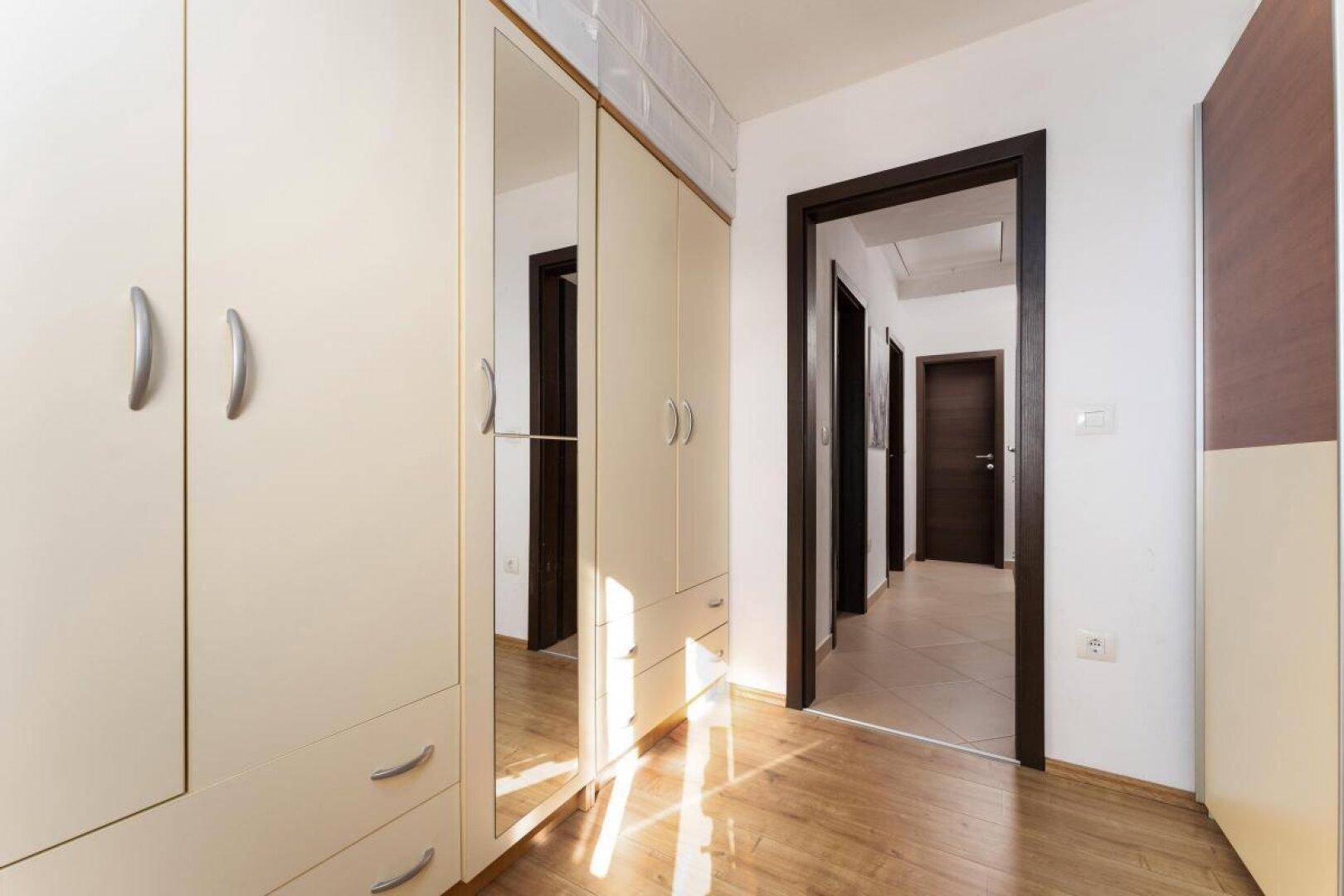 Heller Flur mit großem Spiegelschrank und Zugang zu weiteren Räumen.
