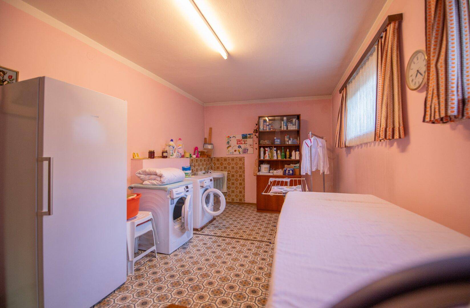 Hauswirtschaftsraum mit Waschmaschinen, Trockner und Stauraum, ideal für den täglichen Bedarf.