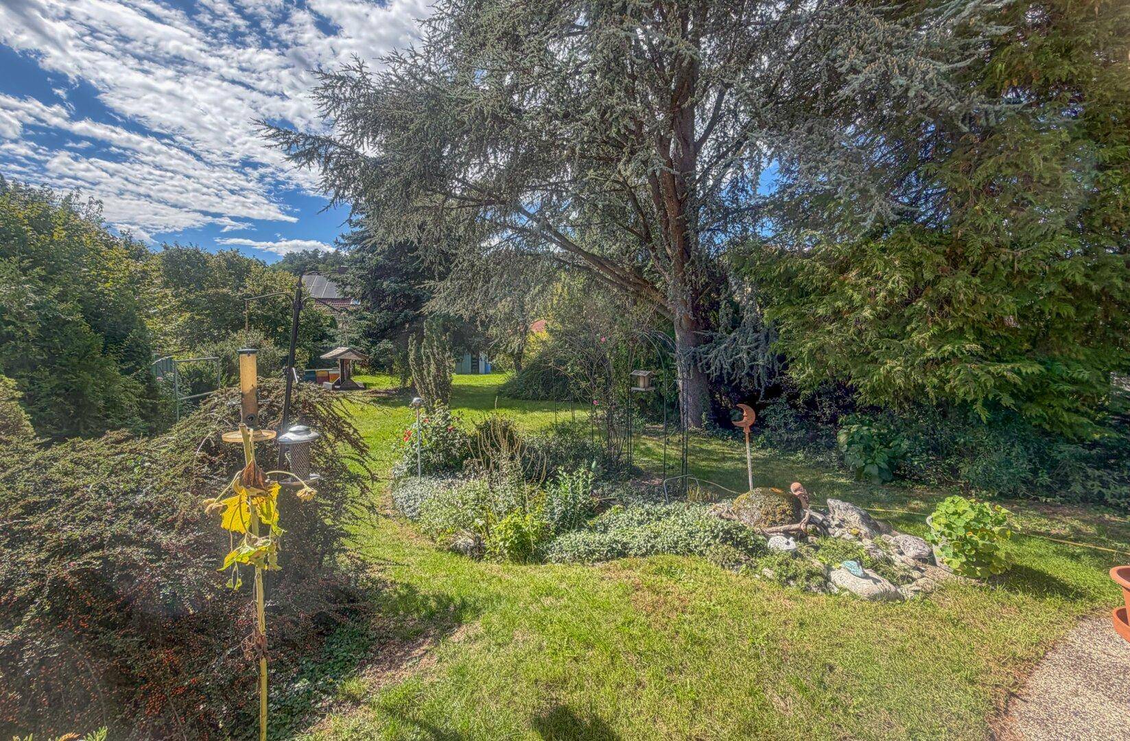 Großer, gepflegter Garten mit Rasenflächen, Bäumen und Sträuchern, bietet viel Platz im Freien.