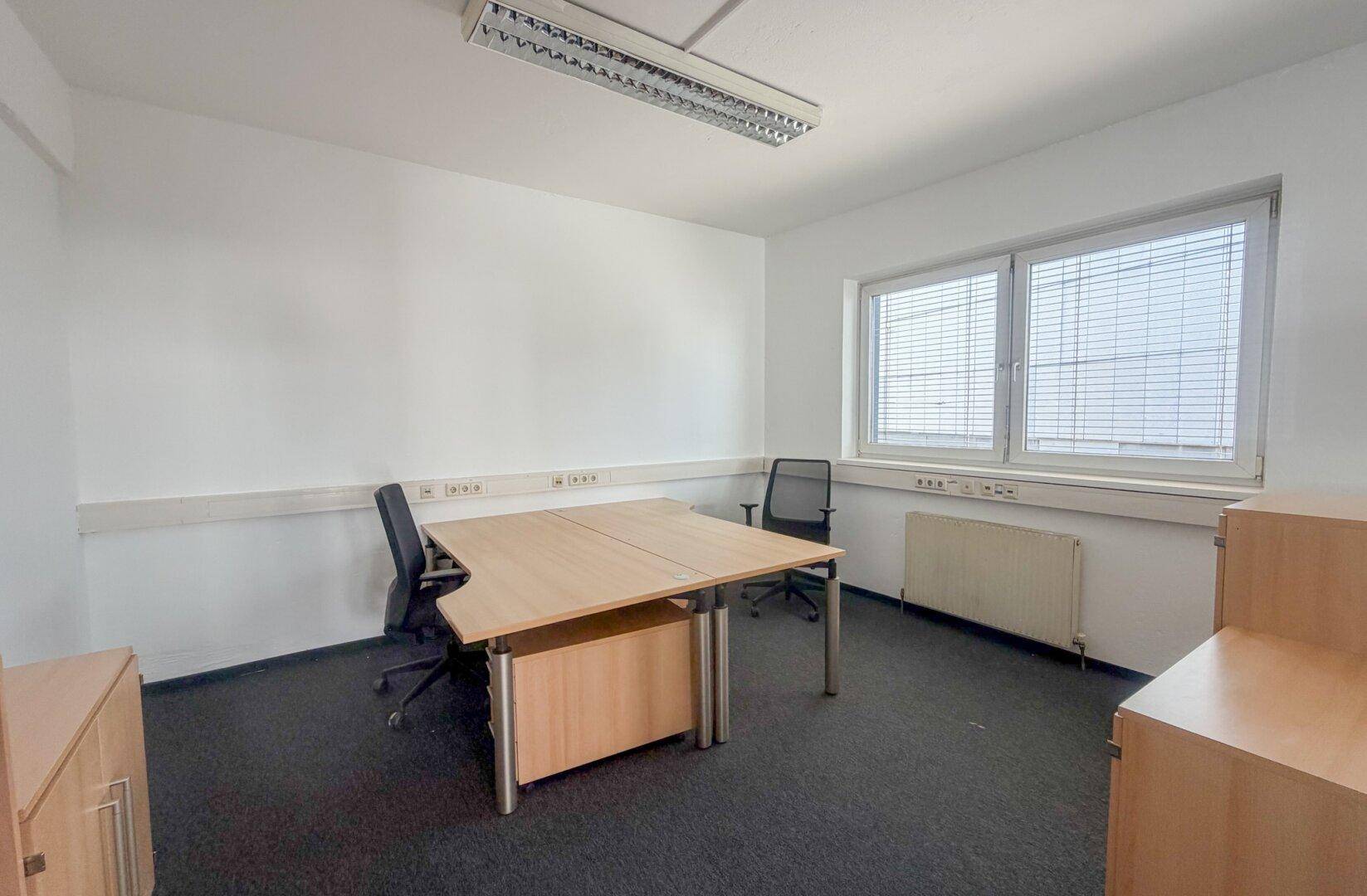 Einzelbüro mit Schreibtisch, Bürostuhl und großem Fenster für viel Tageslicht.