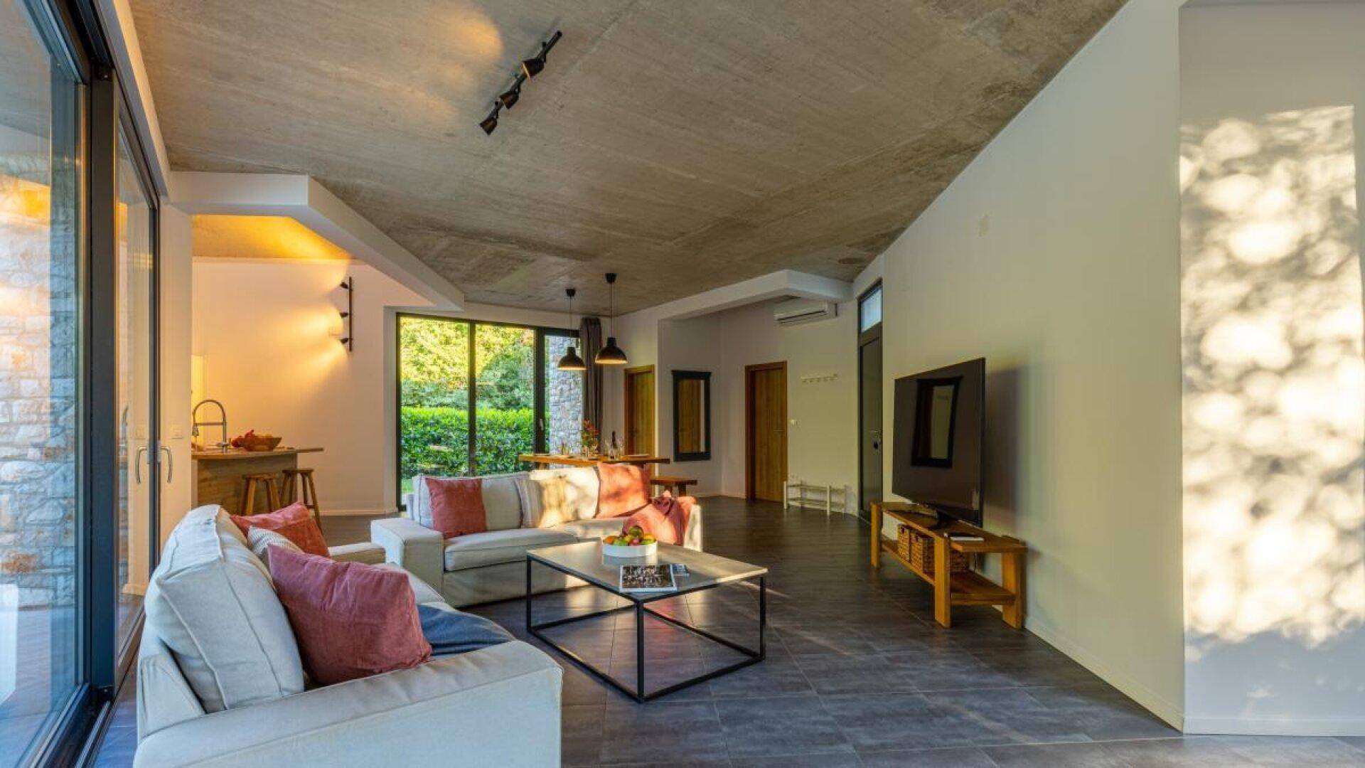 Geräumiger Wohnbereich mit Sofas, Couchtisch und Blick auf den Essbereich und die offene Küche.