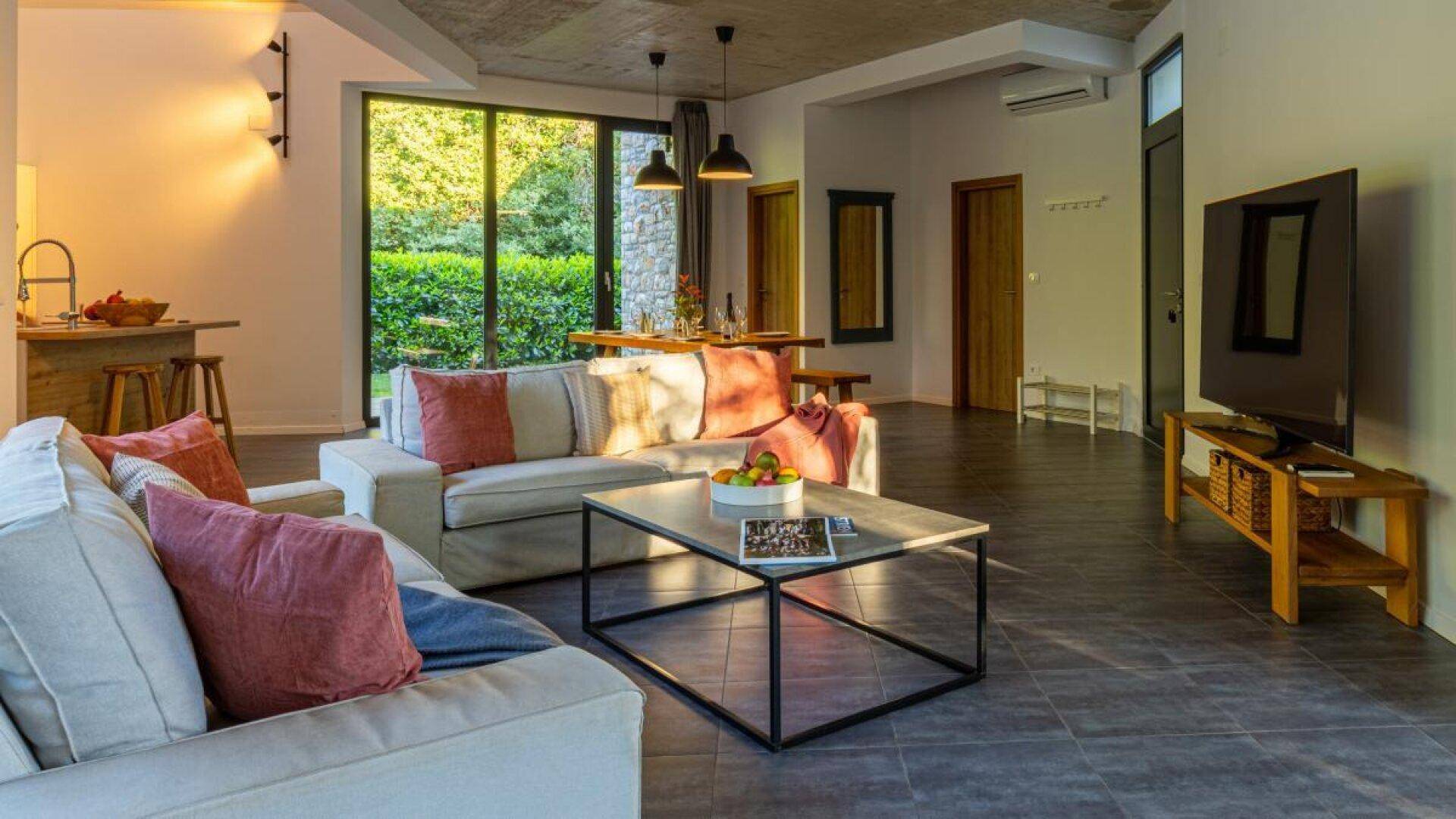 Heller Wohnbereich mit bequemen Sofas, Couchtisch und Blick auf den Essbereich und die Küche.