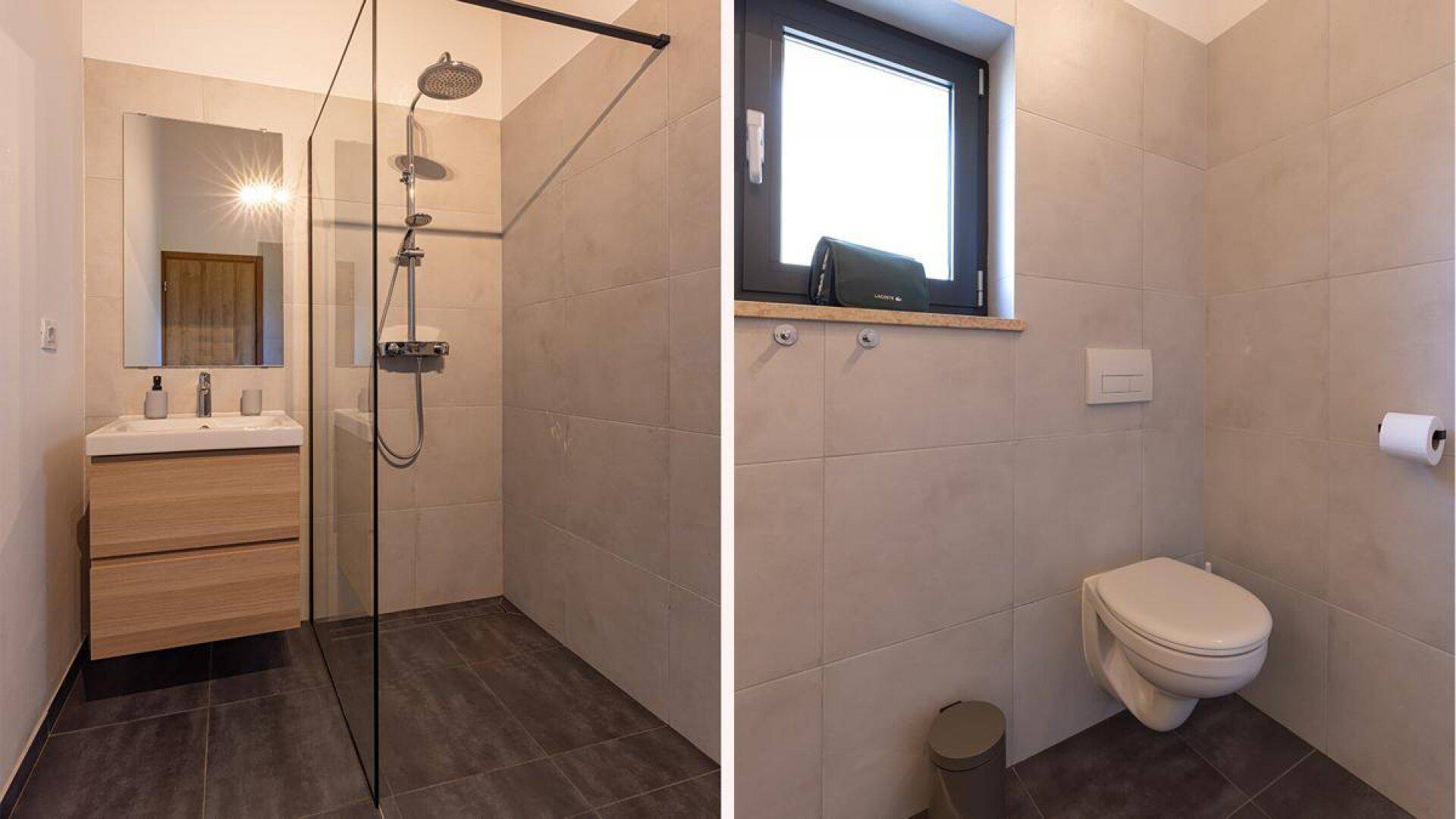 Modernes Badezimmer mit Waschtisch, Dusche und separatem WC-Bereich mit Fenster.