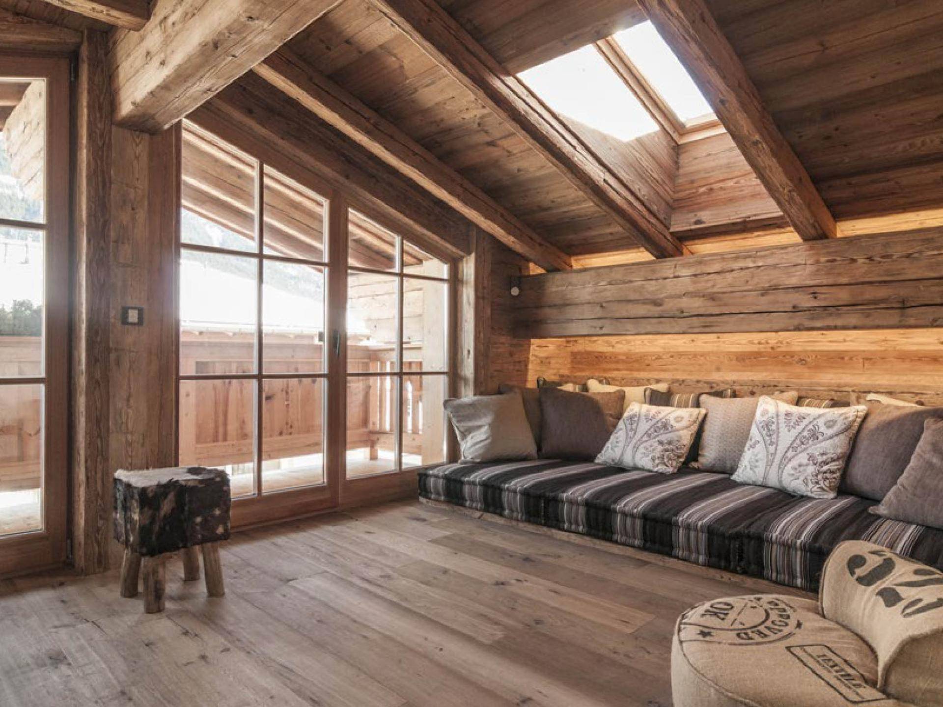 Heller Raum mit Holzwänden, eingebauter Sitzbank, großen Fenstern und Dachfenstern für viel Licht.