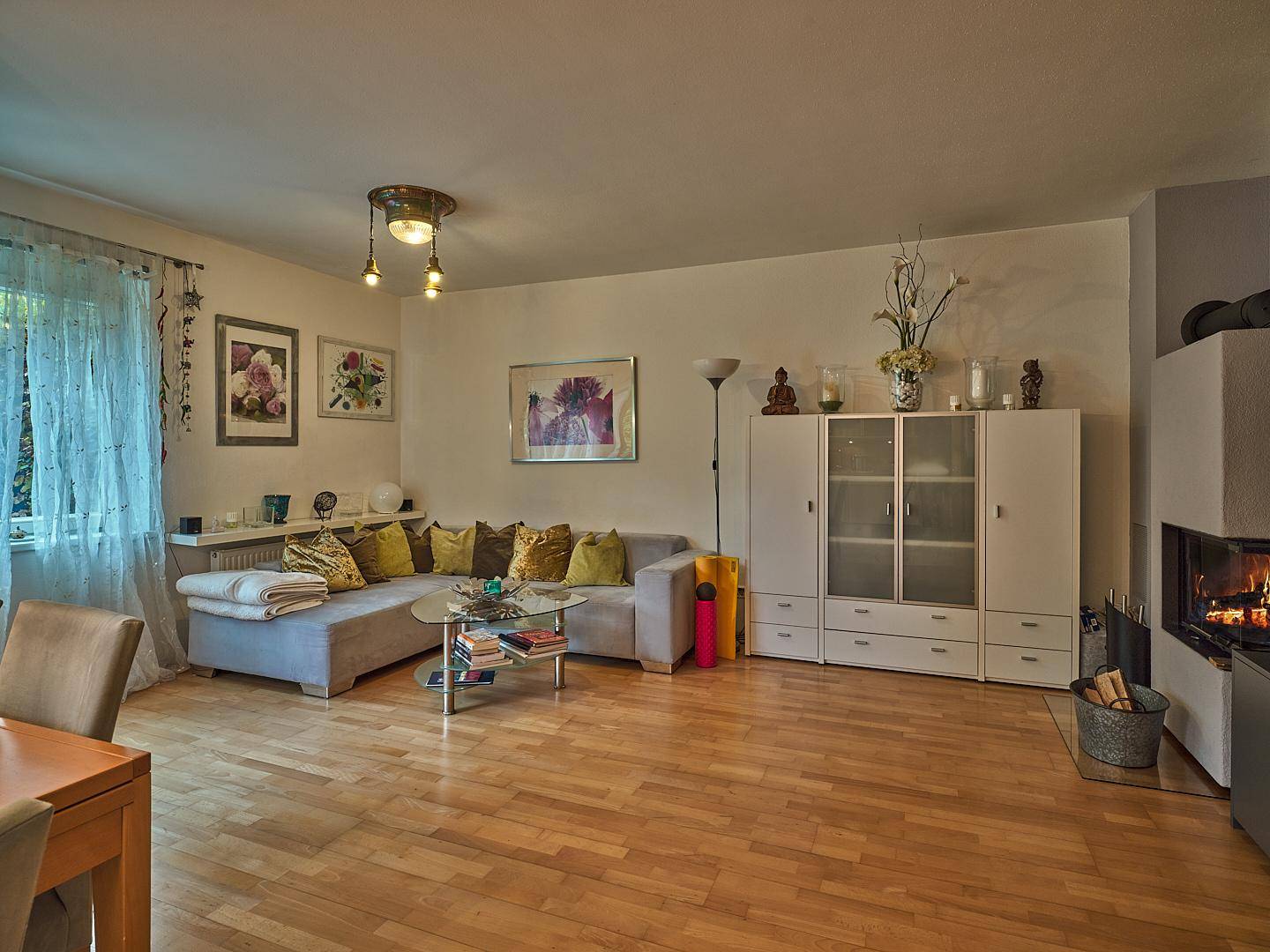 Gemütliches Wohnzimmer mit Kamin, bequemer Couch und hellem Holzboden.