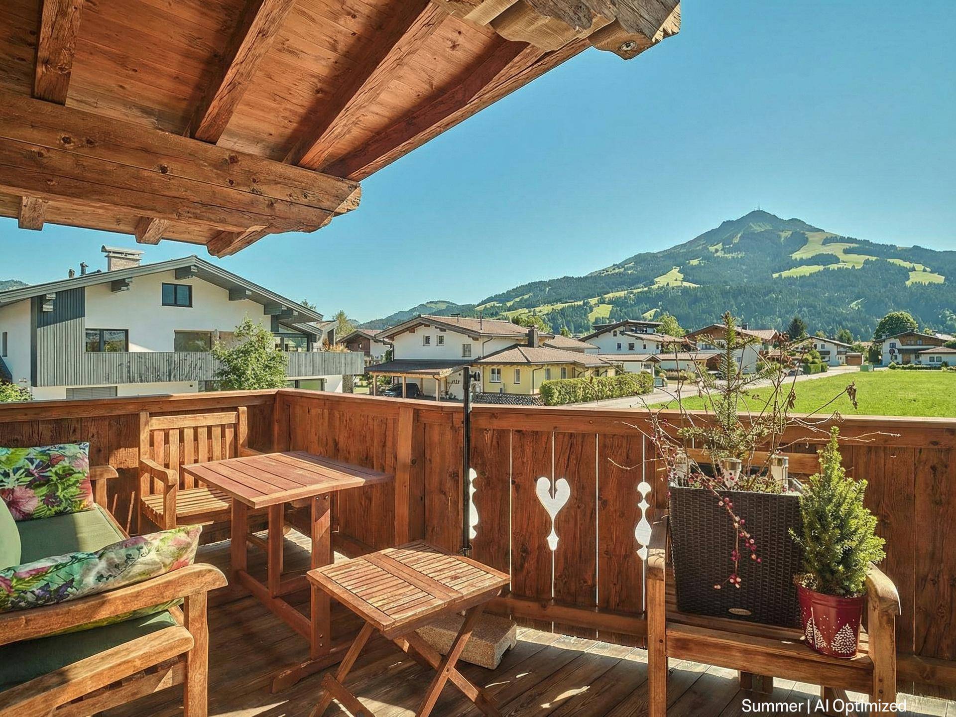 Gemütlicher Holzbalkon mit Sitzgelegenheiten und weitem Blick auf die umliegende Berglandschaft.