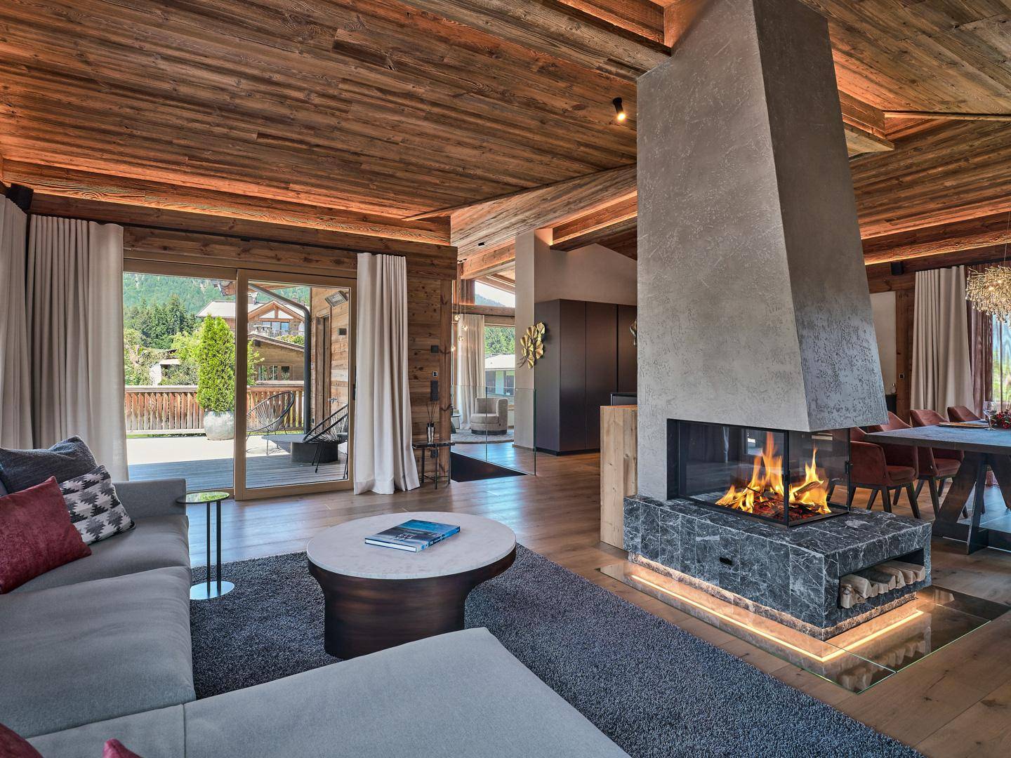 Heller Wohnbereich mit modernem Kamin, bequemer Couch und Zugang zur Terrasse.