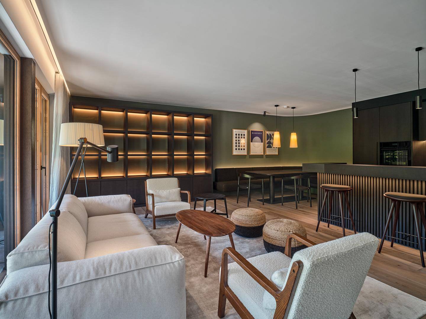 Gemütlicher Wohnbereich mit bequemen Sofas, integriertem Regal und Holzboden.