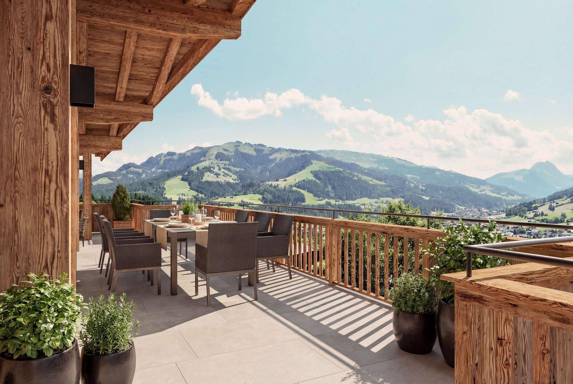 Große Sonnenterrasse mit Esstisch, Pflanzen und atemberaubendem Blick auf die grünen Berge.