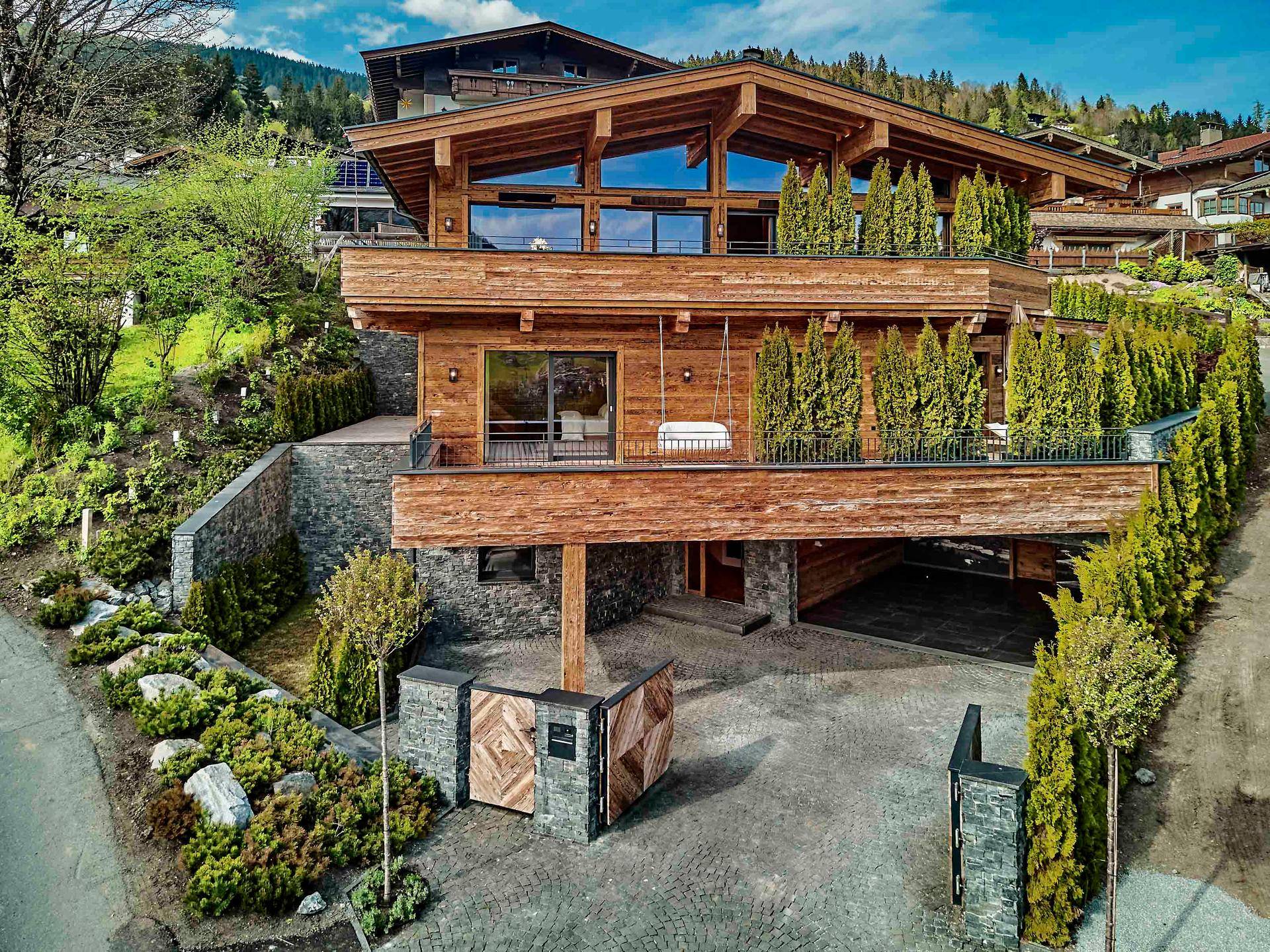 Exklusives Chalet mit moderner Holzfassade, großen Fensterfronten und gepflegter Außenanlage.