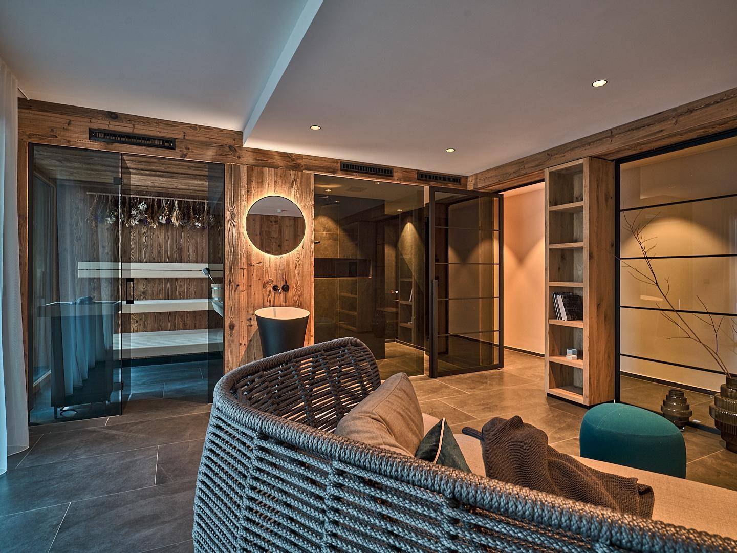 Exklusiver Wellnessbereich mit Sauna, Dusche und stilvoller Entspannungsecke in modernem Design.