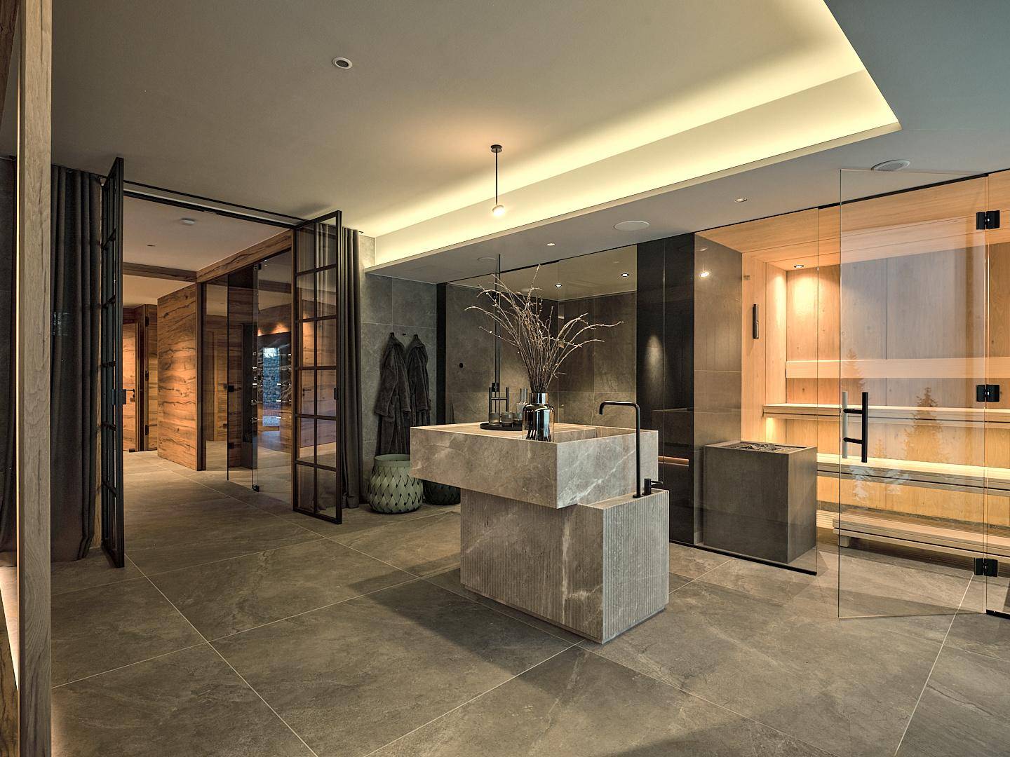 Moderner Wellnessbereich mit Sauna, stilvollem Steinwaschbecken und großformatigen Fliesen.