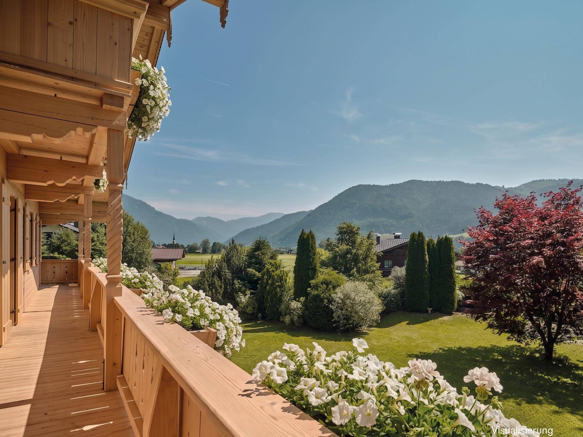 Geräumiger Holzbalkon mit Blumenkästen und weitem Blick über das grüne Tal und die Berge.