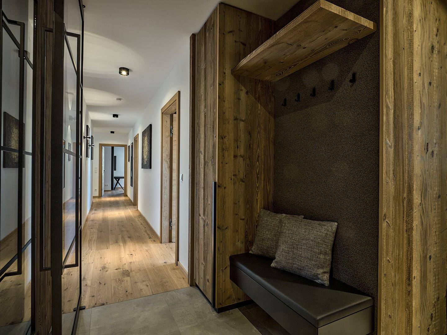 Heller Flur mit Holzelementen, Garderobe und Sitzbank im modernen Design.