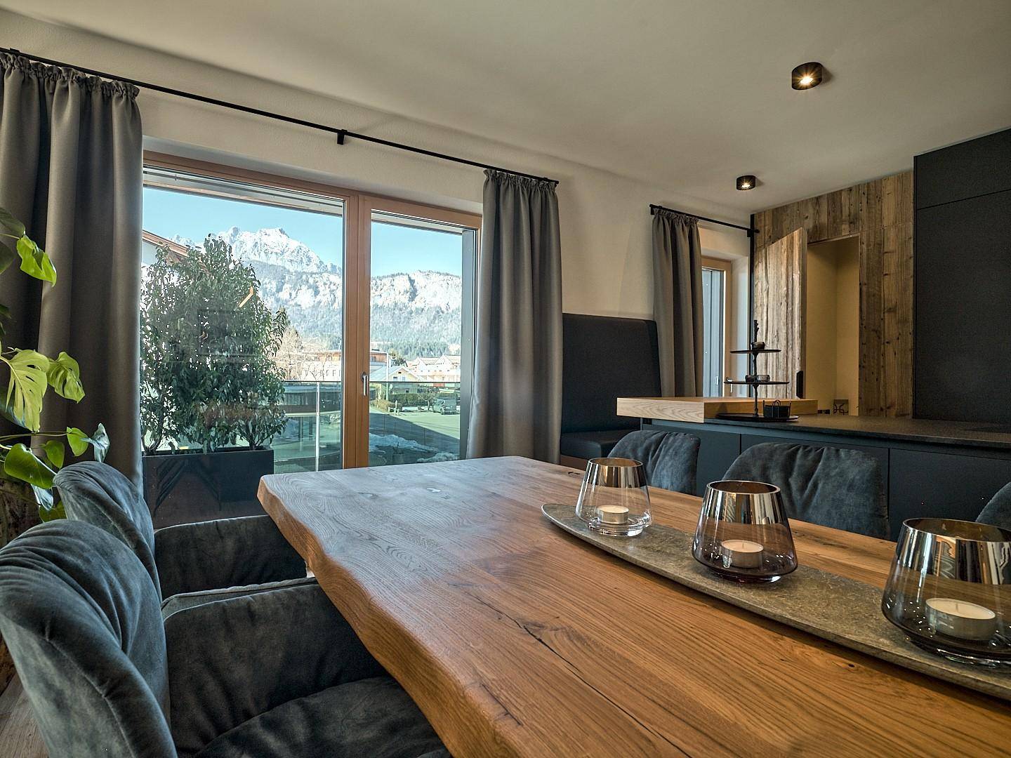 Essbereich mit rustikalem Holztisch und Panoramablick auf die umliegenden Berge.