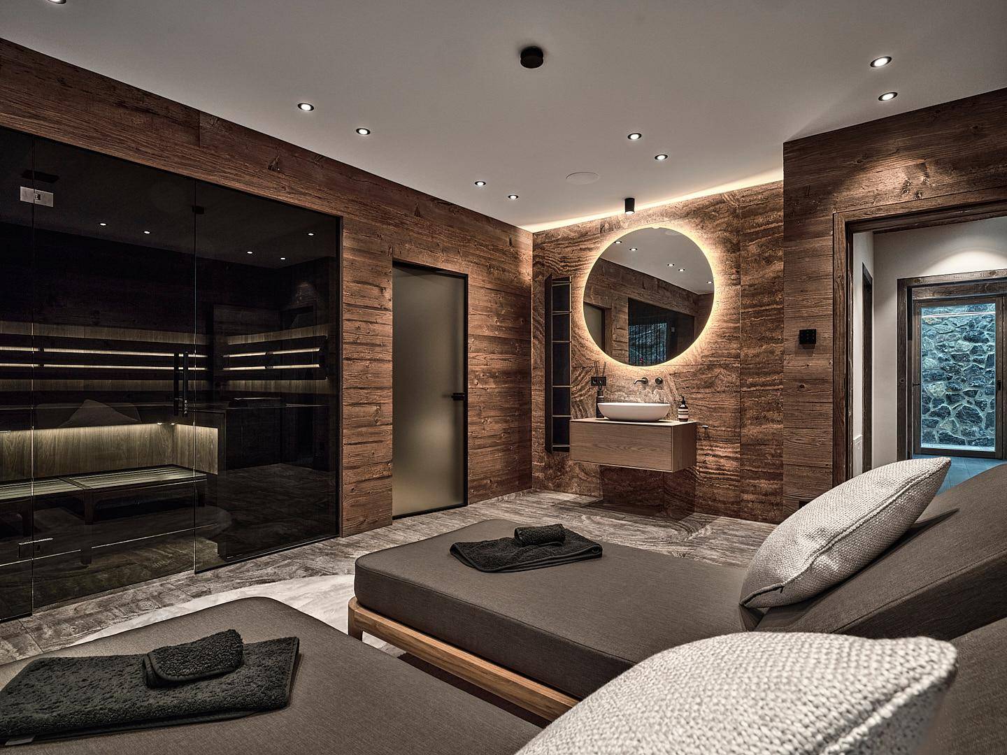Exklusiver Wellnessbereich mit Sauna, Ruheliegen und modernem Waschbecken.
