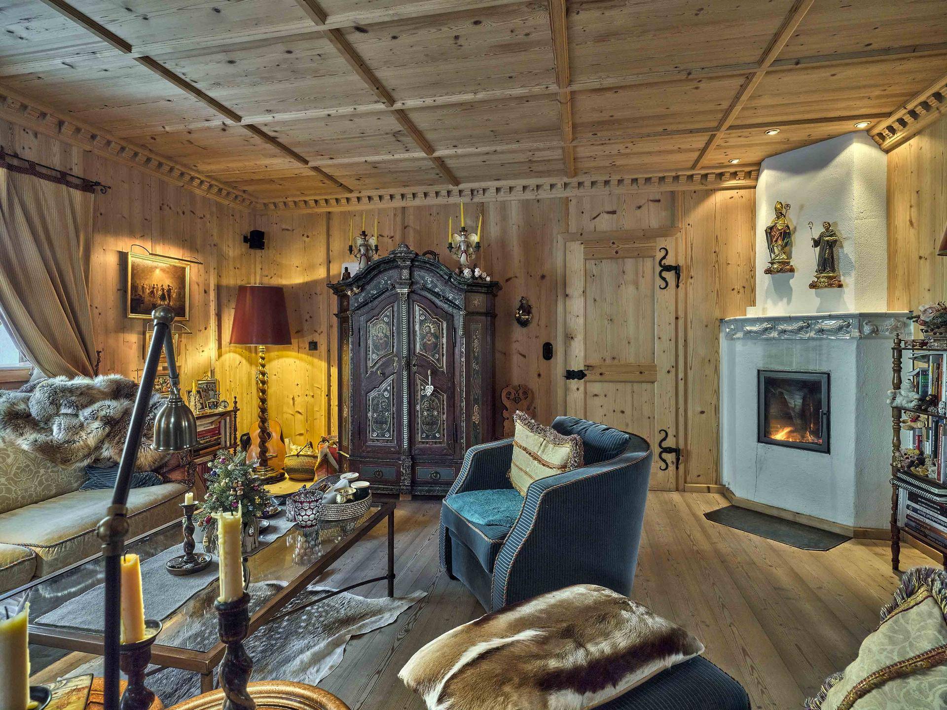 Rustikales Wohnzimmer mit Holztäfelung, modernem Kamin und bequemen Sitzgelegenheiten.