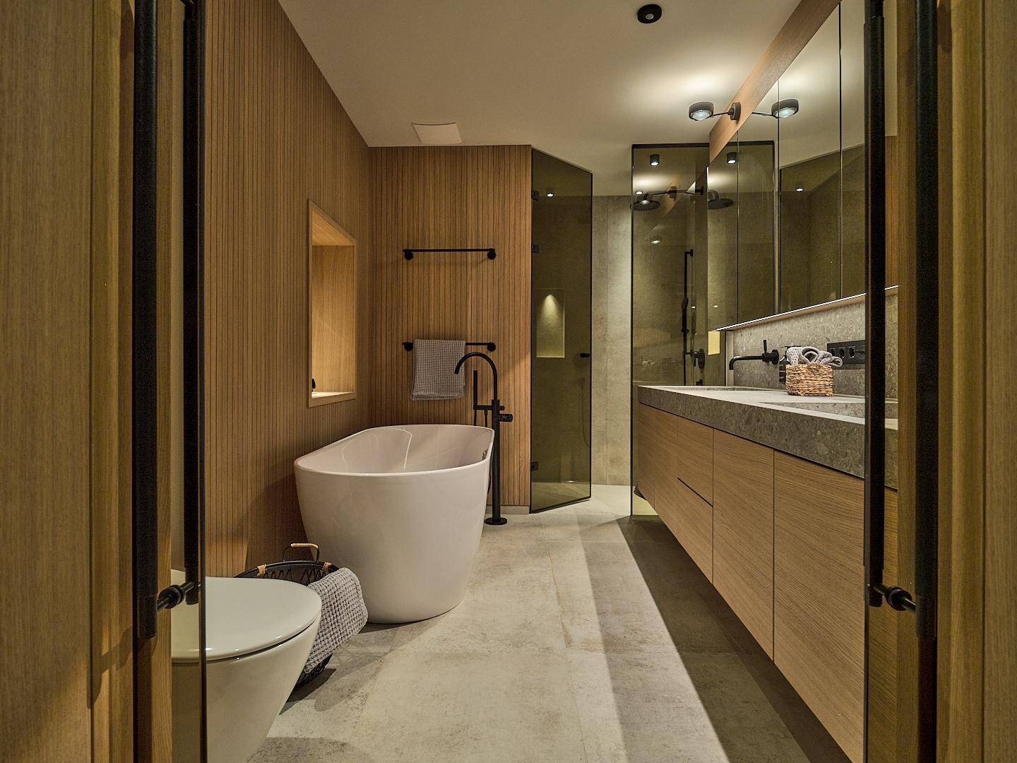 Modernes Badezimmer mit freistehender Badewanne, begehbarer Dusche und Holzvertäfelung.
