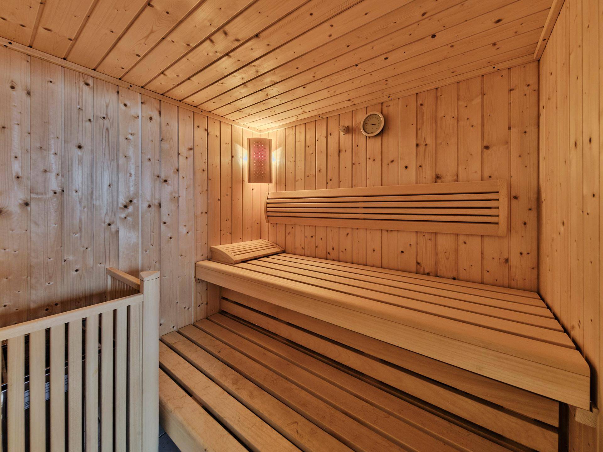 Traditionelle Holzsauna mit Bänken und Heizofen für entspannende Momente.