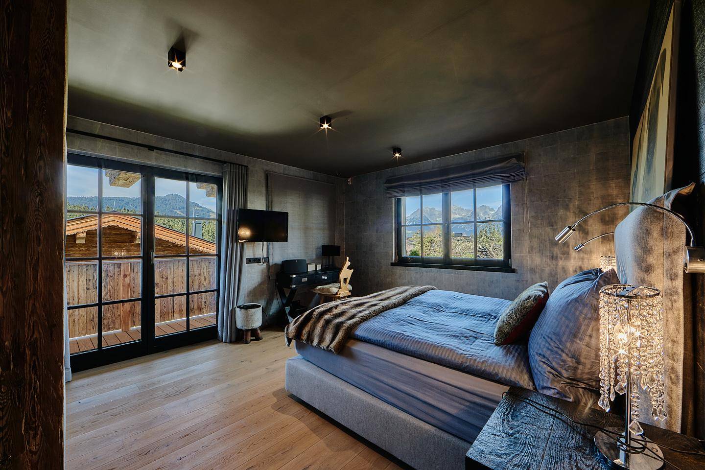 Gemütliches Schlafzimmer mit Balkonzugang, Holzboden und malerischem Bergblick.