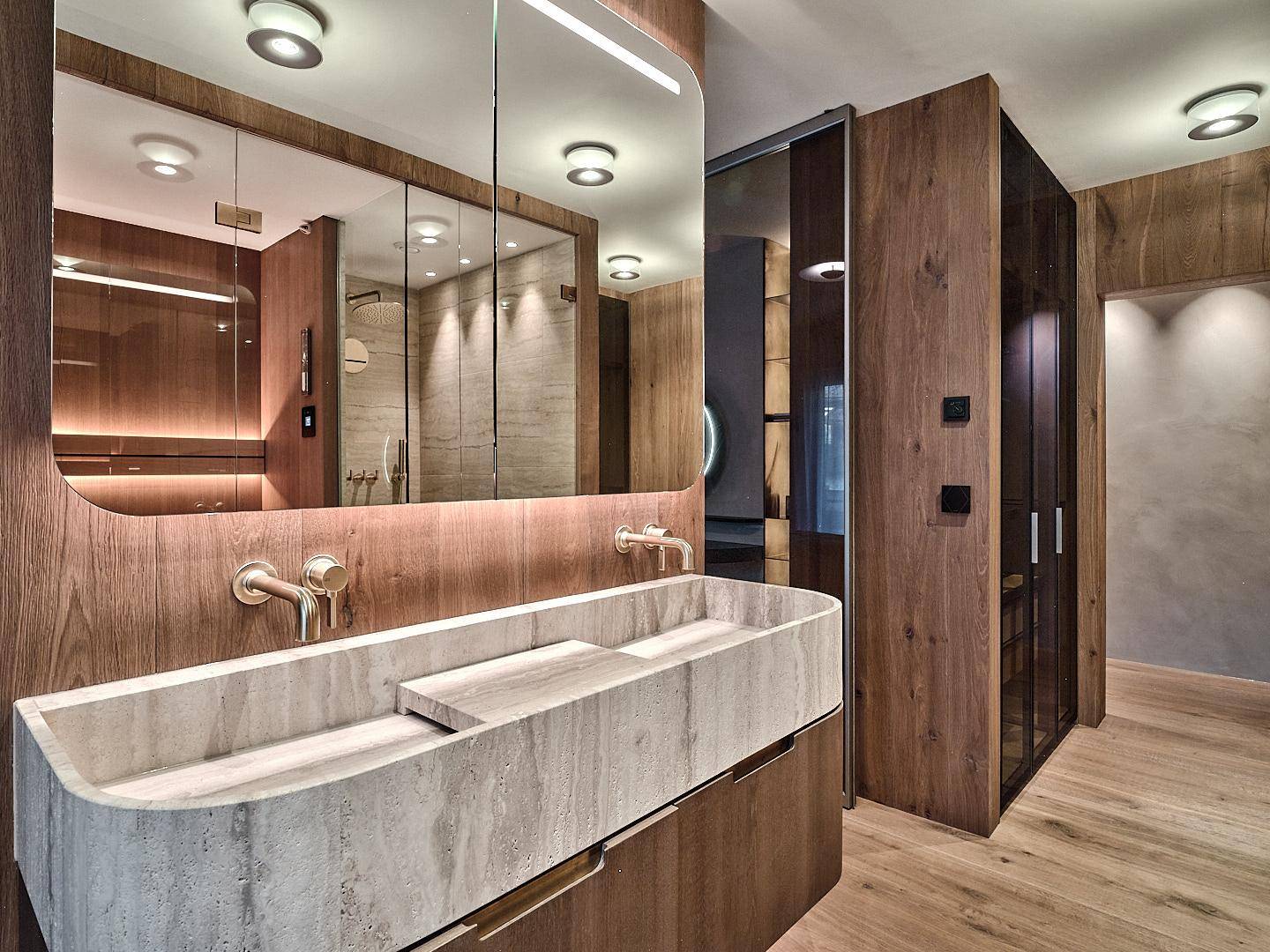 Elegantes Badezimmer mit Doppelwaschbecken, großem Spiegel und hochwertigen Holzschränken.