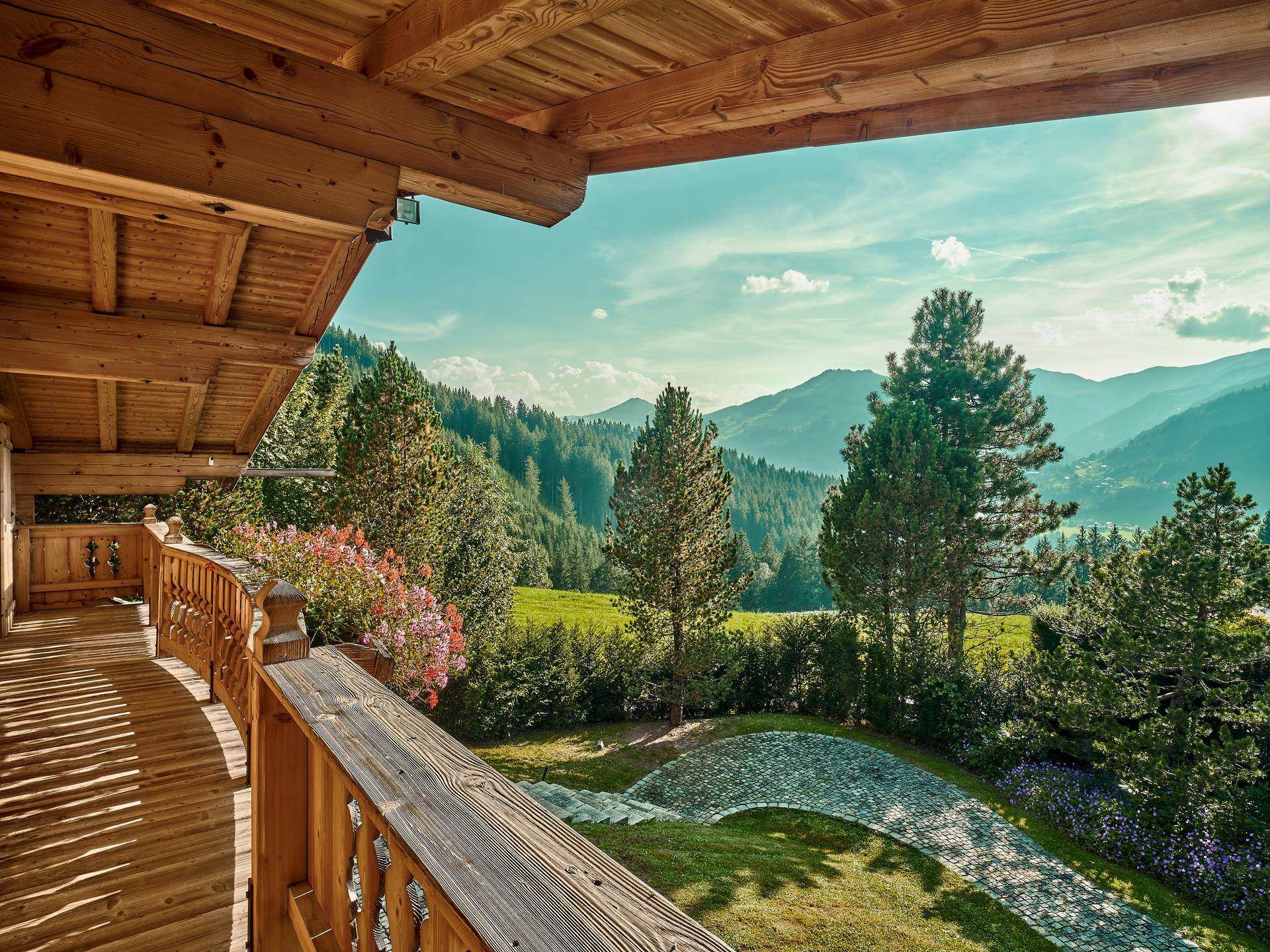 Holzbalkon mit Blumenkästen und atemberaubendem Blick auf die umliegende Berglandschaft.