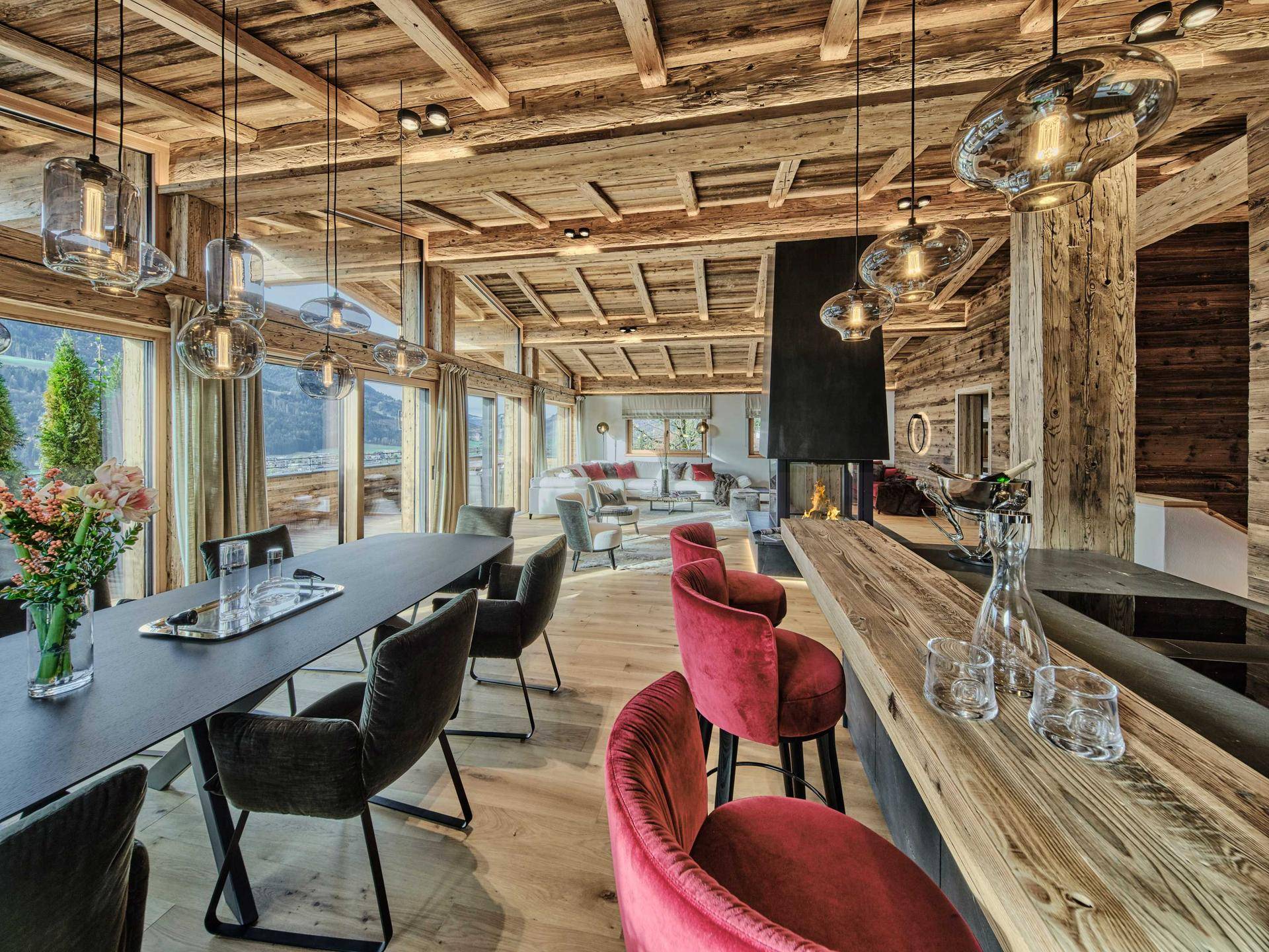 Eleganter Essbereich mit Bar und Blick auf die Berge, integriert in den offenen Wohnbereich.