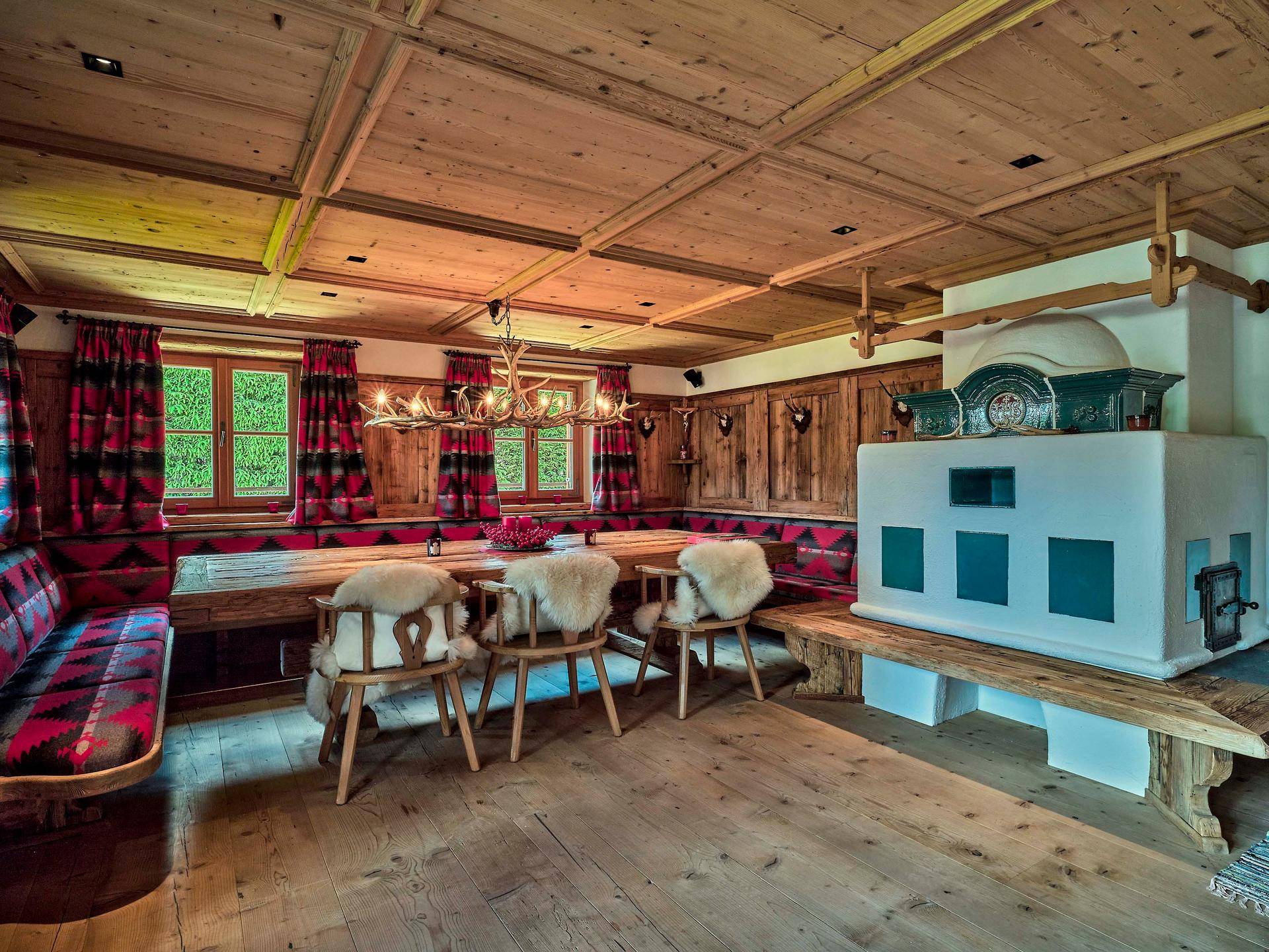 Gemütlicher Essbereich im alpinen Stil mit Holztäfelung, Kachelofen und traditionellen Sitzgelegenheiten.
