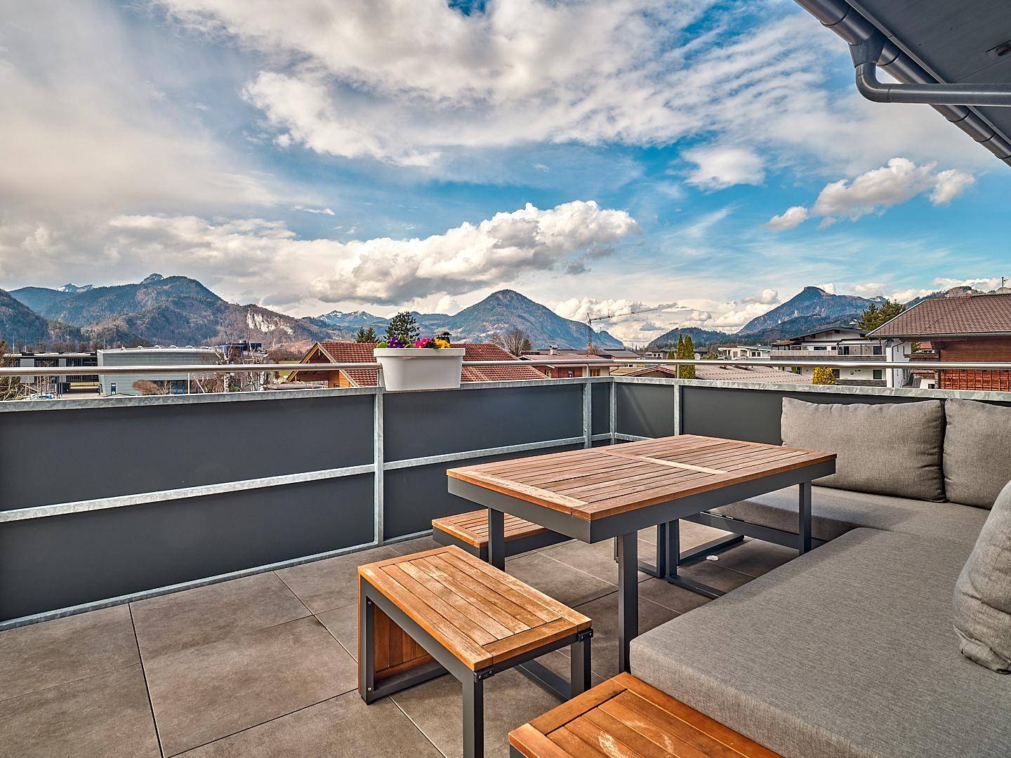 Geräumige Terrasse mit modernen Gartenmöbeln und beeindruckendem Panoramablick auf die Berge.