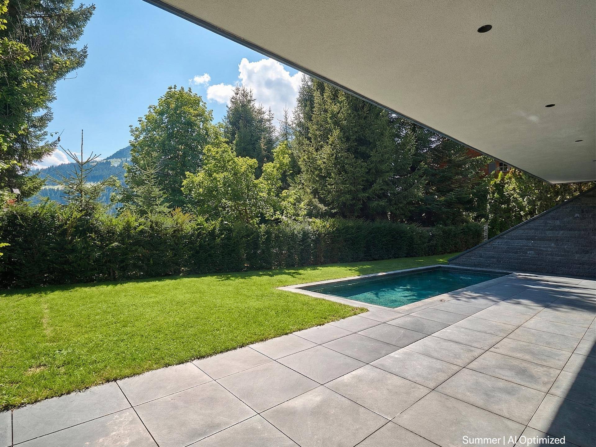 Sonniger Außenbereich mit gepflegtem Rasen, kleinem Pool und weitläufiger Terrasse umgeben von Bäumen.