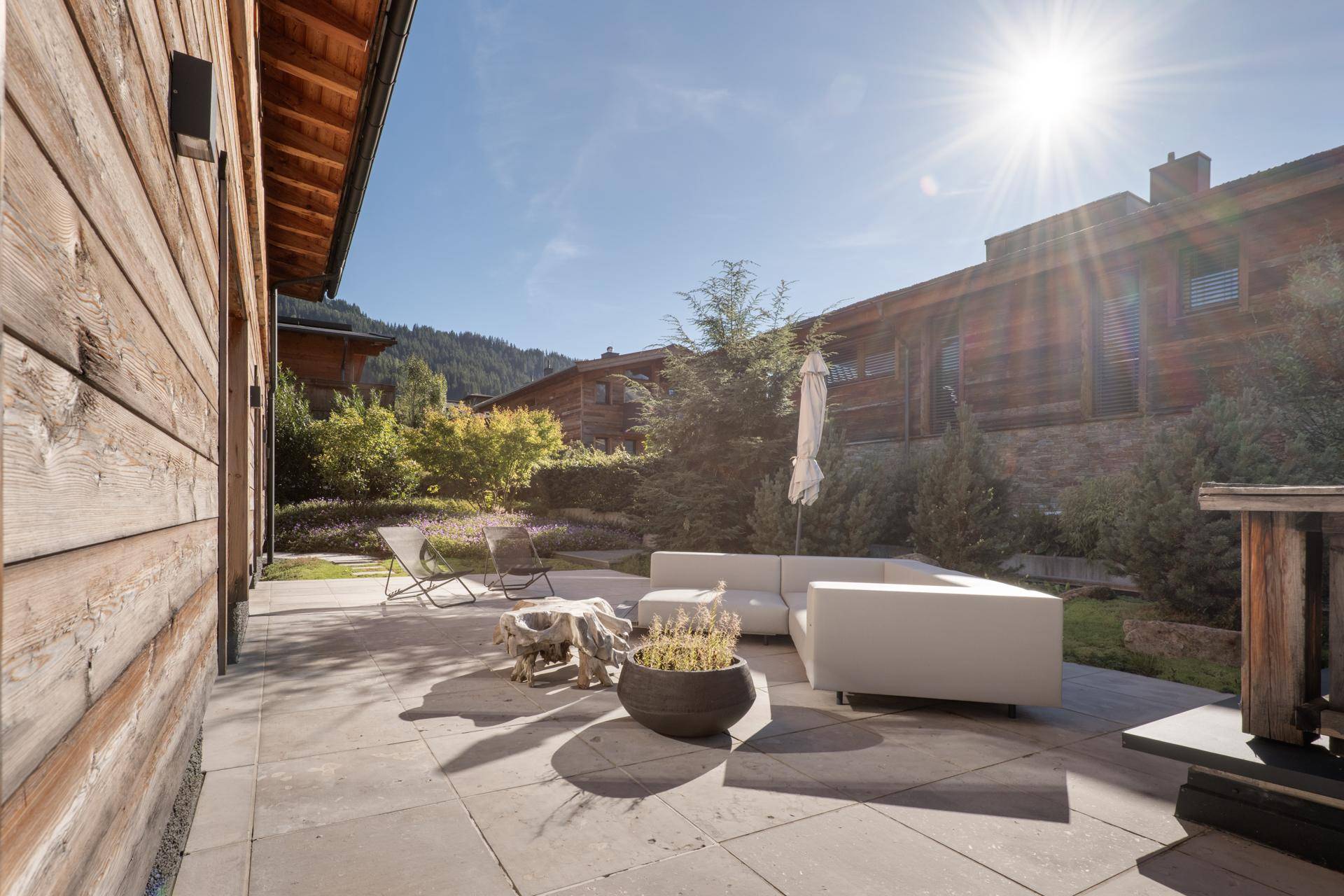 Sonnige Terrasse mit bequemen Gartenmöbeln und Zugang zum gepflegten Gartenbereich.