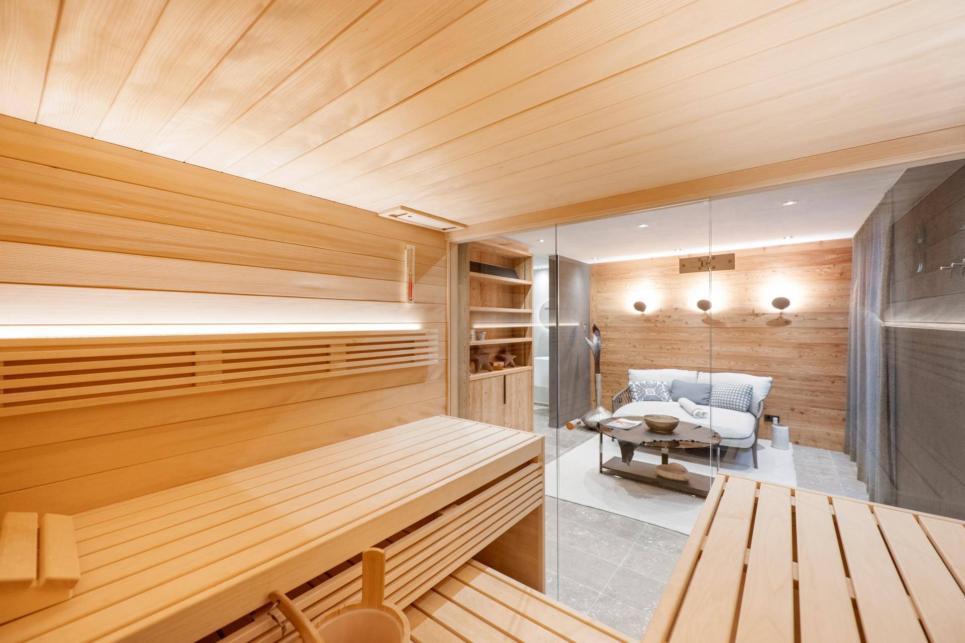 Moderner Wellnessbereich mit Holzsauna und angrenzendem Ruhebereich für Entspannung.