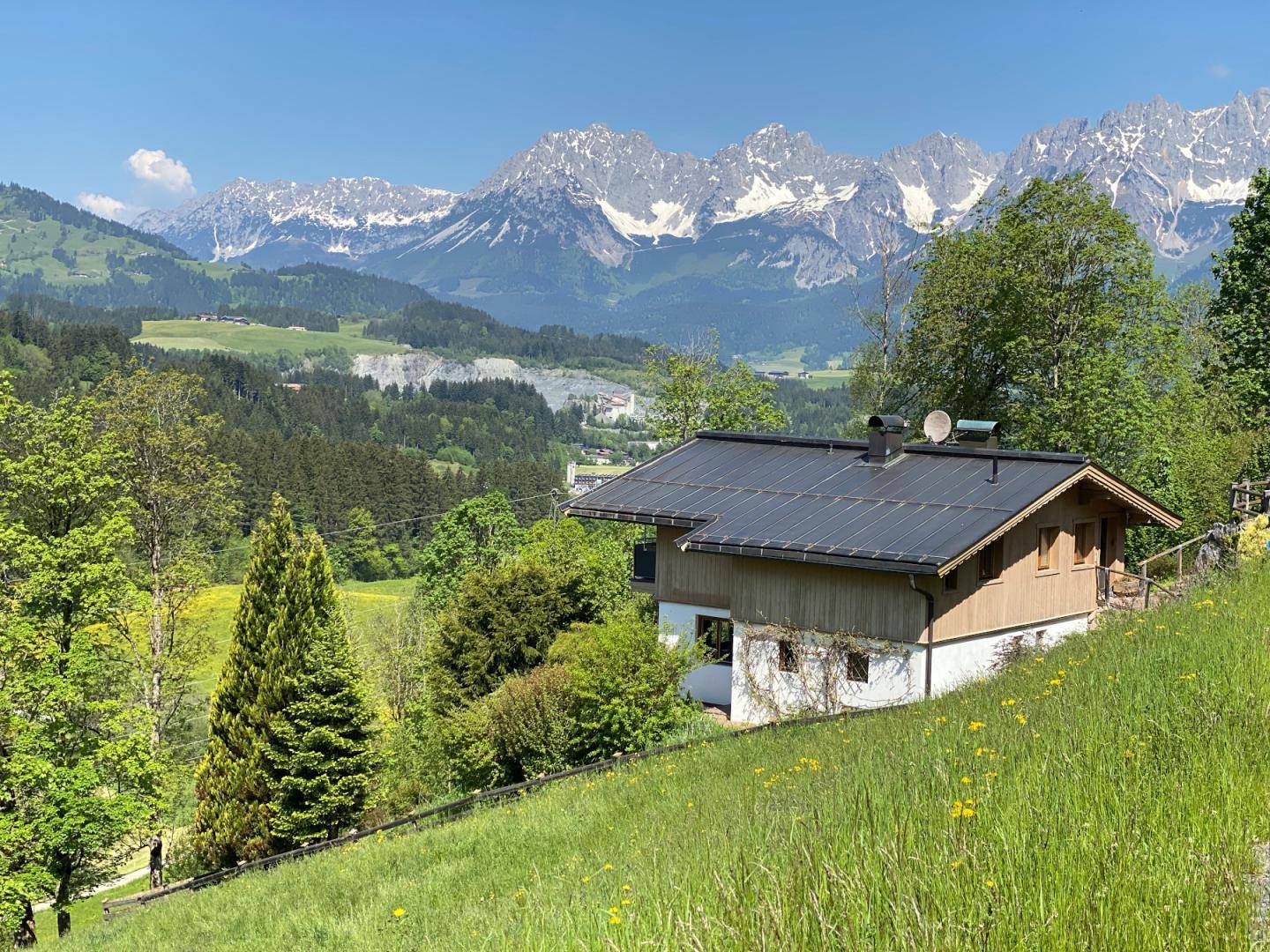 Haus in idyllischer Hanglage mit weitem Blick auf die majestätischen schneebedeckten Berge.