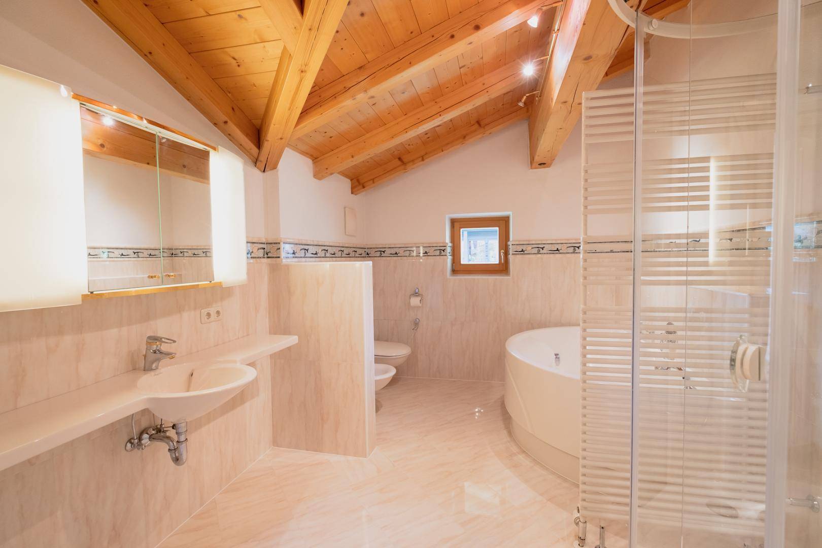 Geräumiges Badezimmer mit Fliesen, Holzbalkendecke, Eckbadewanne, Dusche und Fenster.