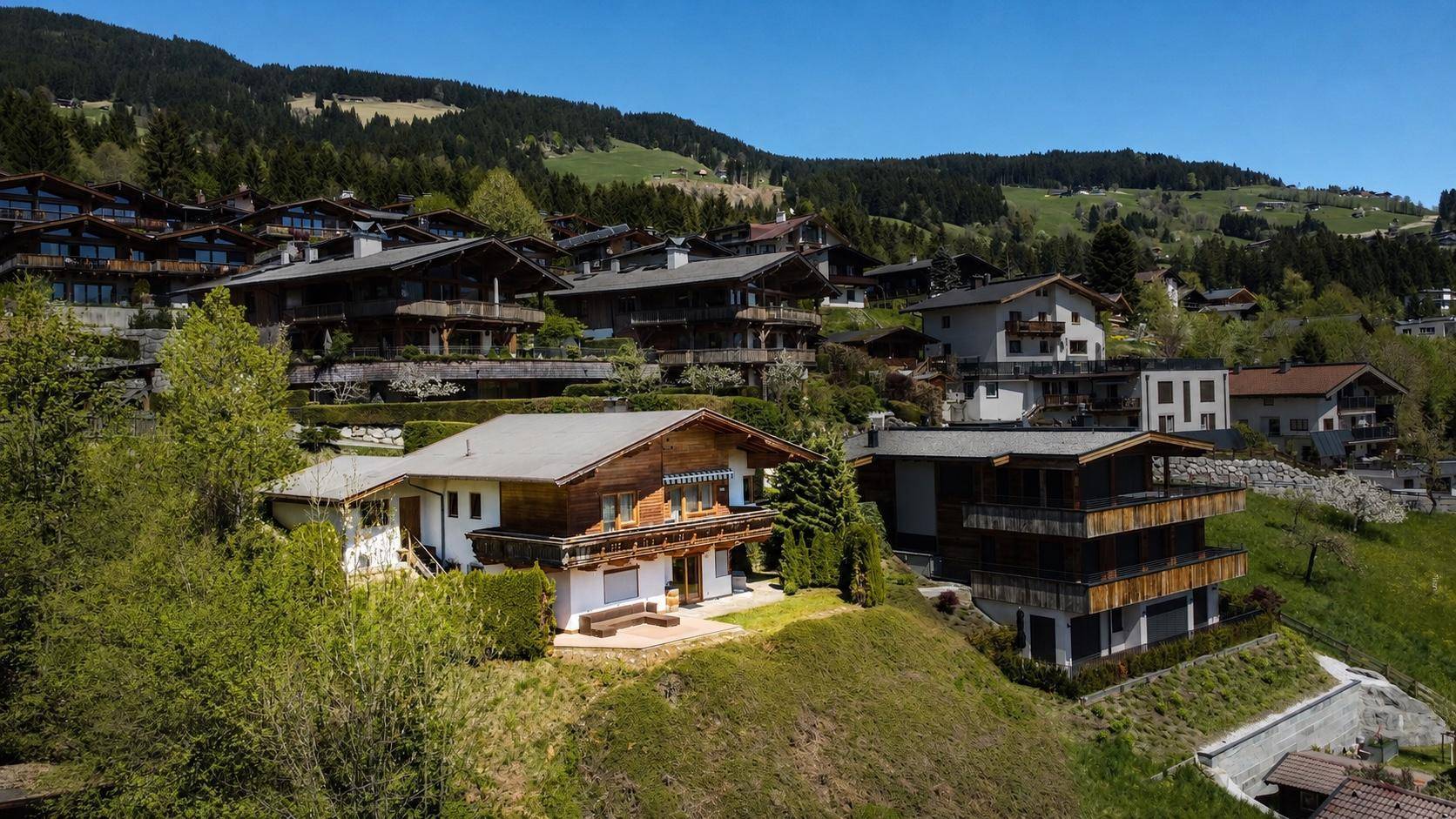 Panoramablick auf ein charmantes Chalet mit Holzbalkonen in einer malerischen Berglandschaft.