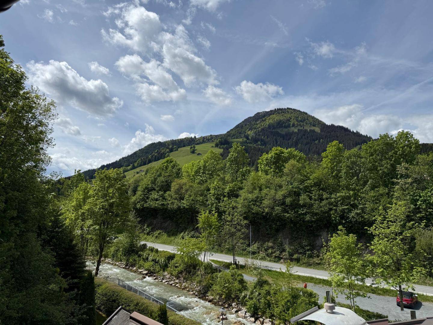 Idyllischer Blick auf einen Fluss und die bewaldeten Berge, der eine ruhige Naturkulisse bietet.