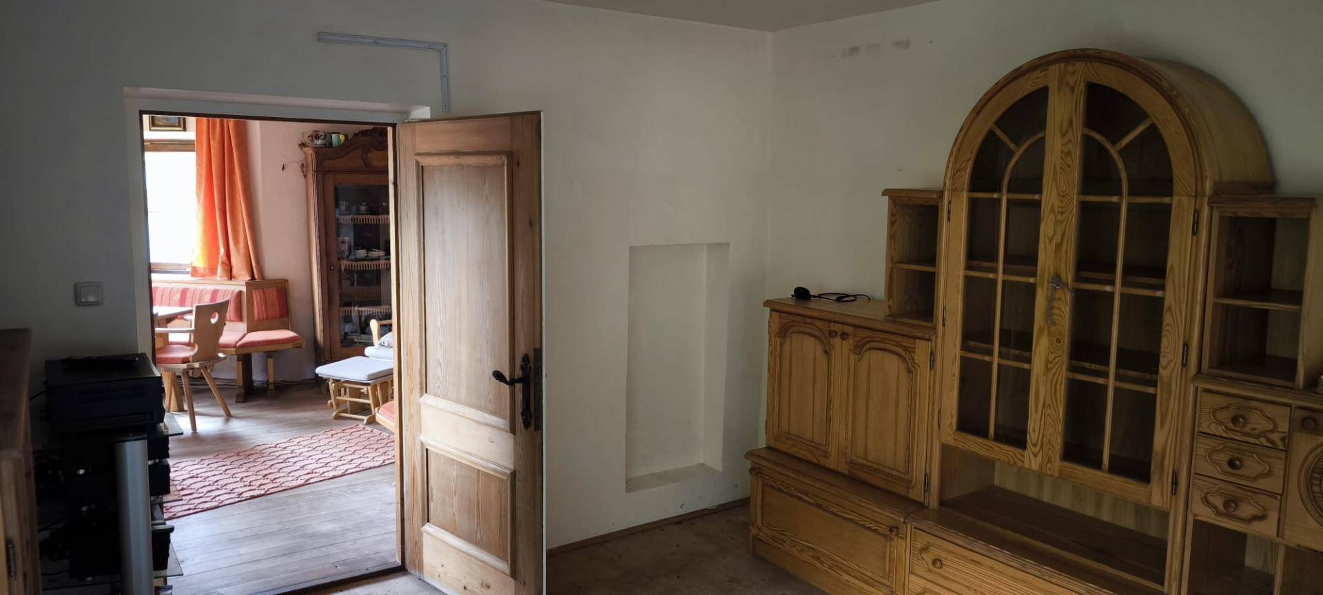 Heller Flur mit Holztüren und traditionellen Holzmöbeln, der in einen Essbereich führt.
