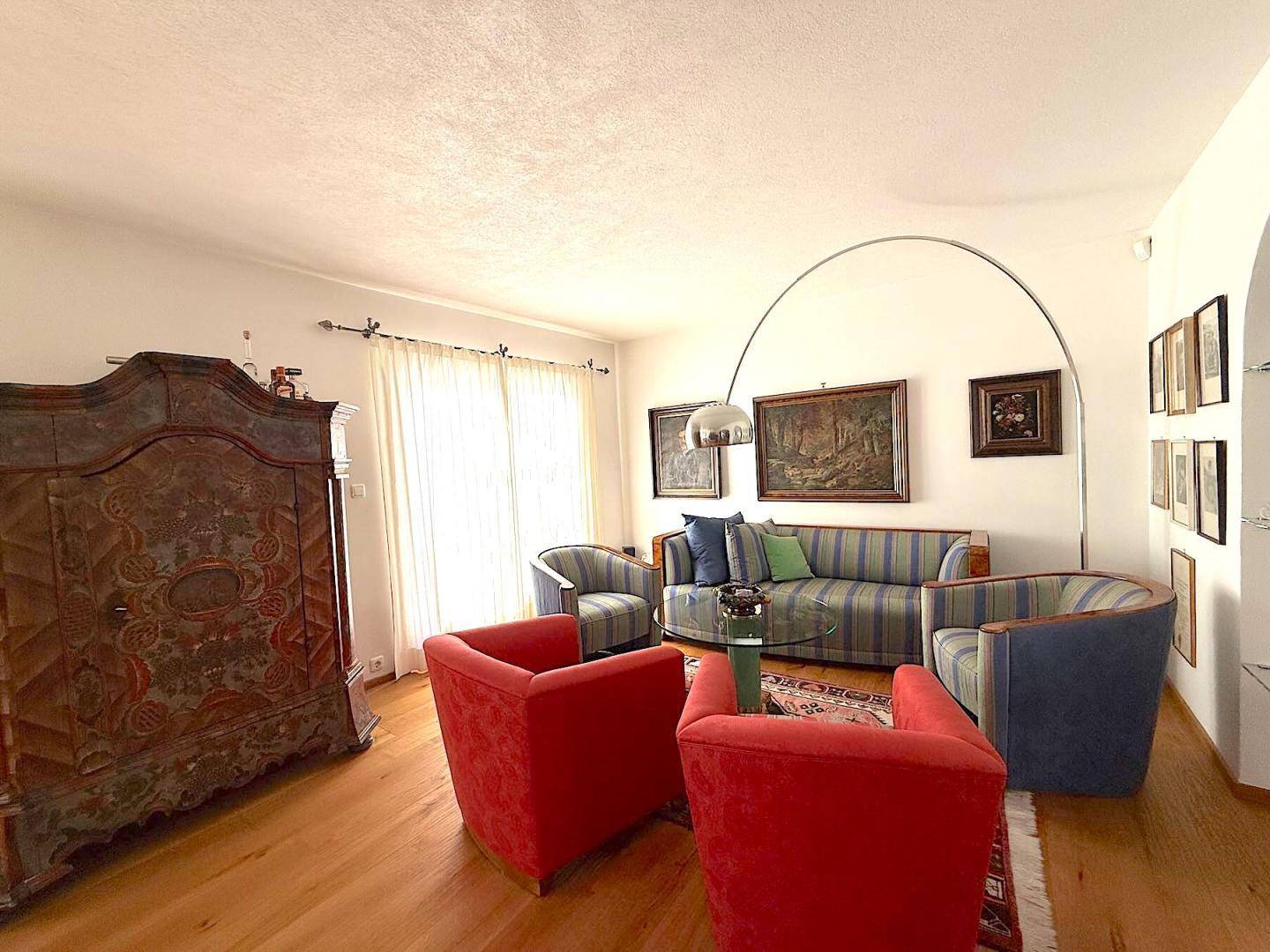 Gemütliches Wohnzimmer mit traditionellen Möbeln, Holzboden und viel Tageslicht.