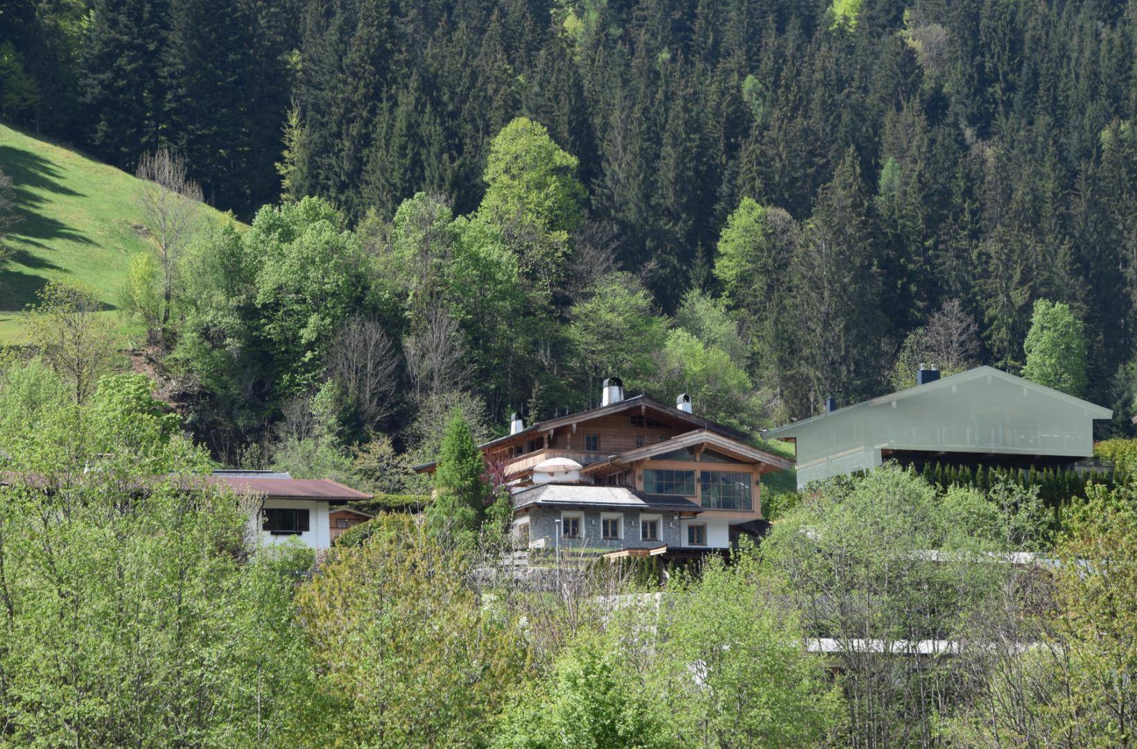 Charmantes Chalet-Haus eingebettet in eine üppige grüne Hügellandschaft mit dichten Wäldern.