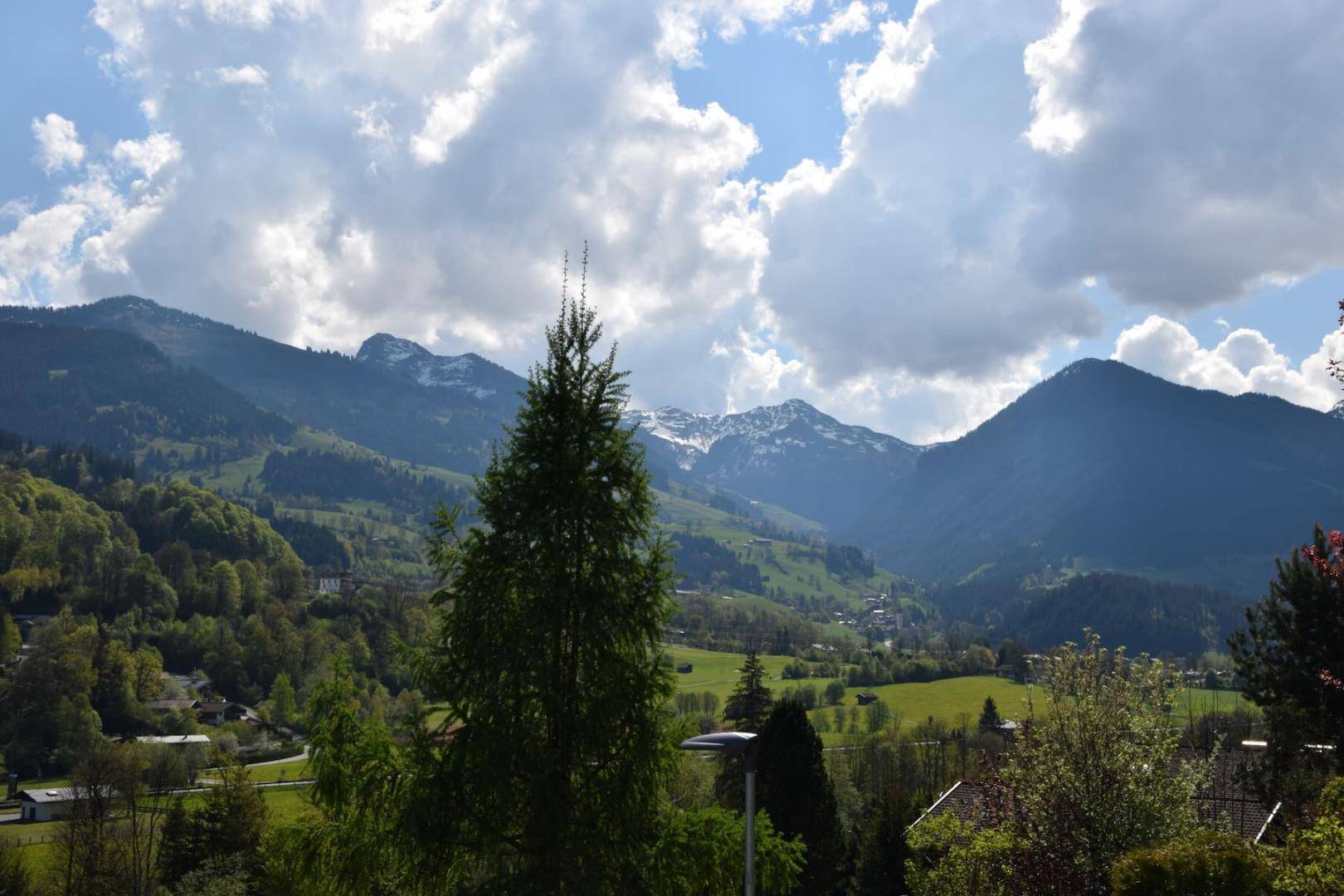 Weitläufiger Panoramablick auf die grüne Berglandschaft mit bewaldeten Hängen und Tälern.
