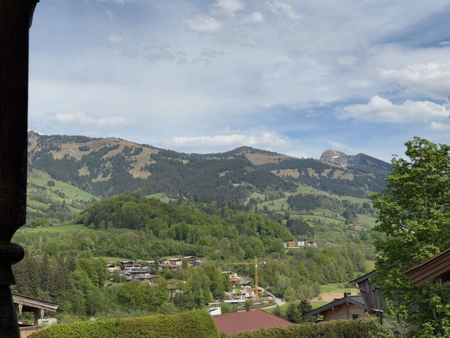 Panoramablick auf die umliegende Berglandschaft und grüne Hügel.