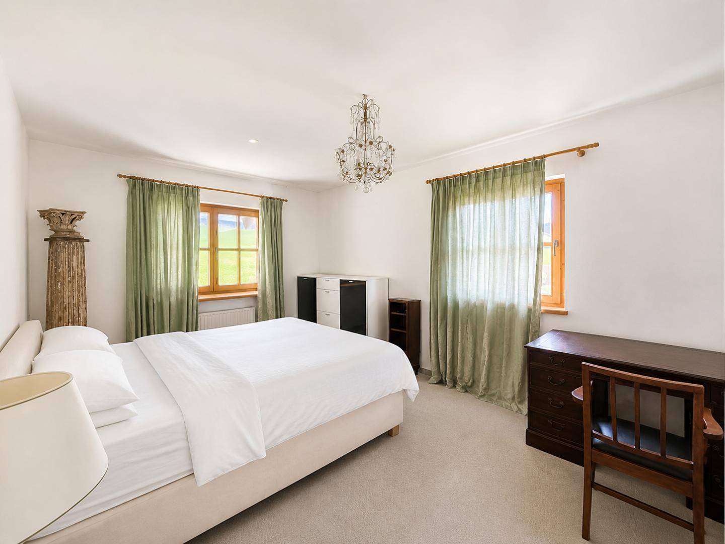 Ruhiges Schlafzimmer mit Teppichboden, hellen Wänden und Blick auf die Landschaft.