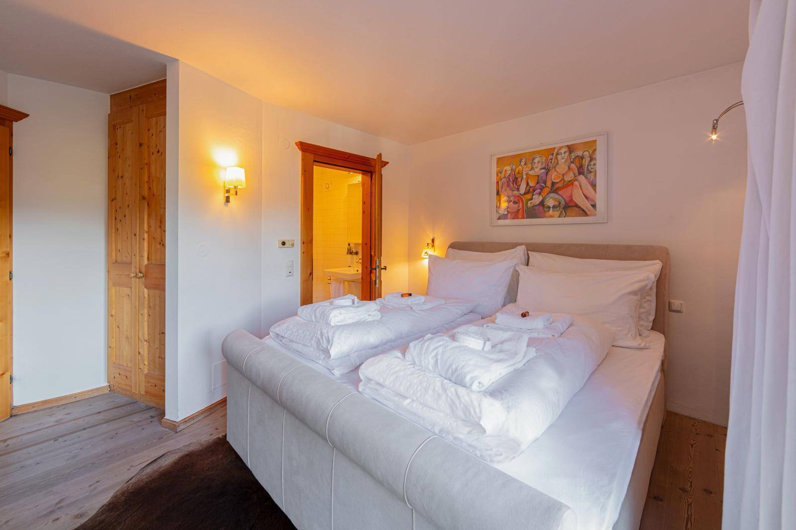 Komfortables Schlafzimmer mit großem Bett, Einbauschränken und direktem Zugang zum Bad.