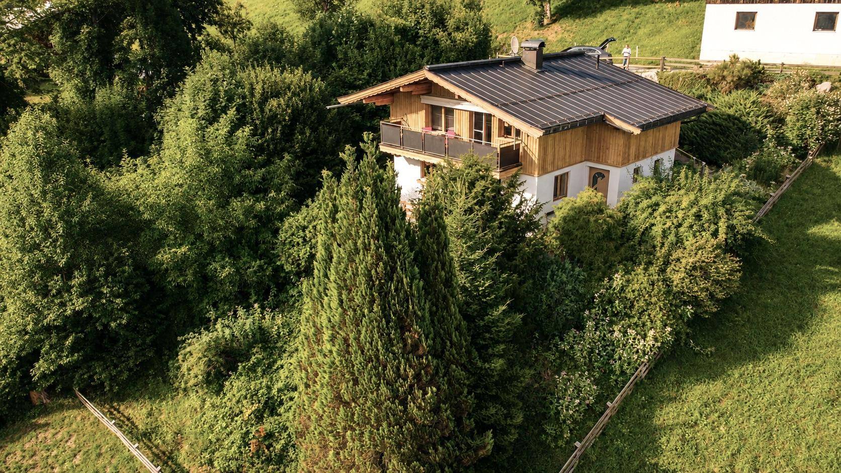 Charmantes Haus im Grünen mit Balkon und traditioneller Holzfassade.