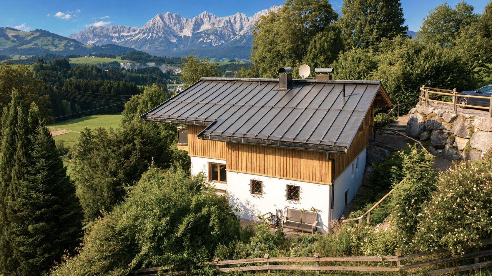 Alpines Haus mit Holzelementen und Blick auf die majestätischen Berge.