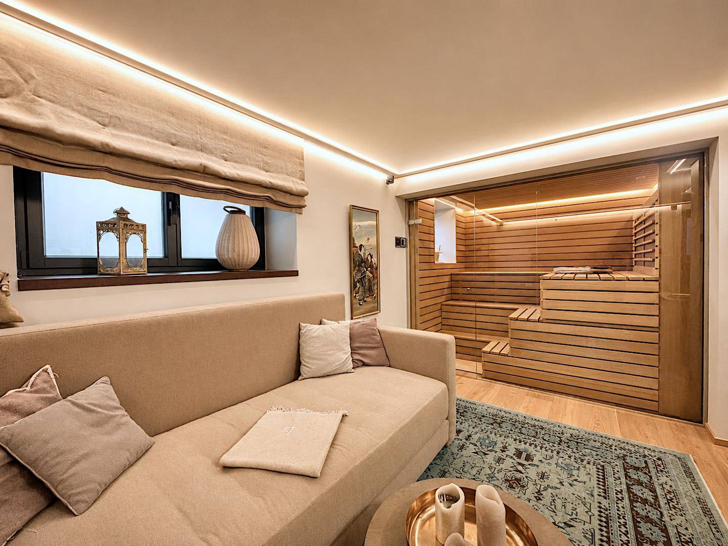 Entspannungsbereich mit bequemer Couch und integrierter Sauna für Wellnessmomente.